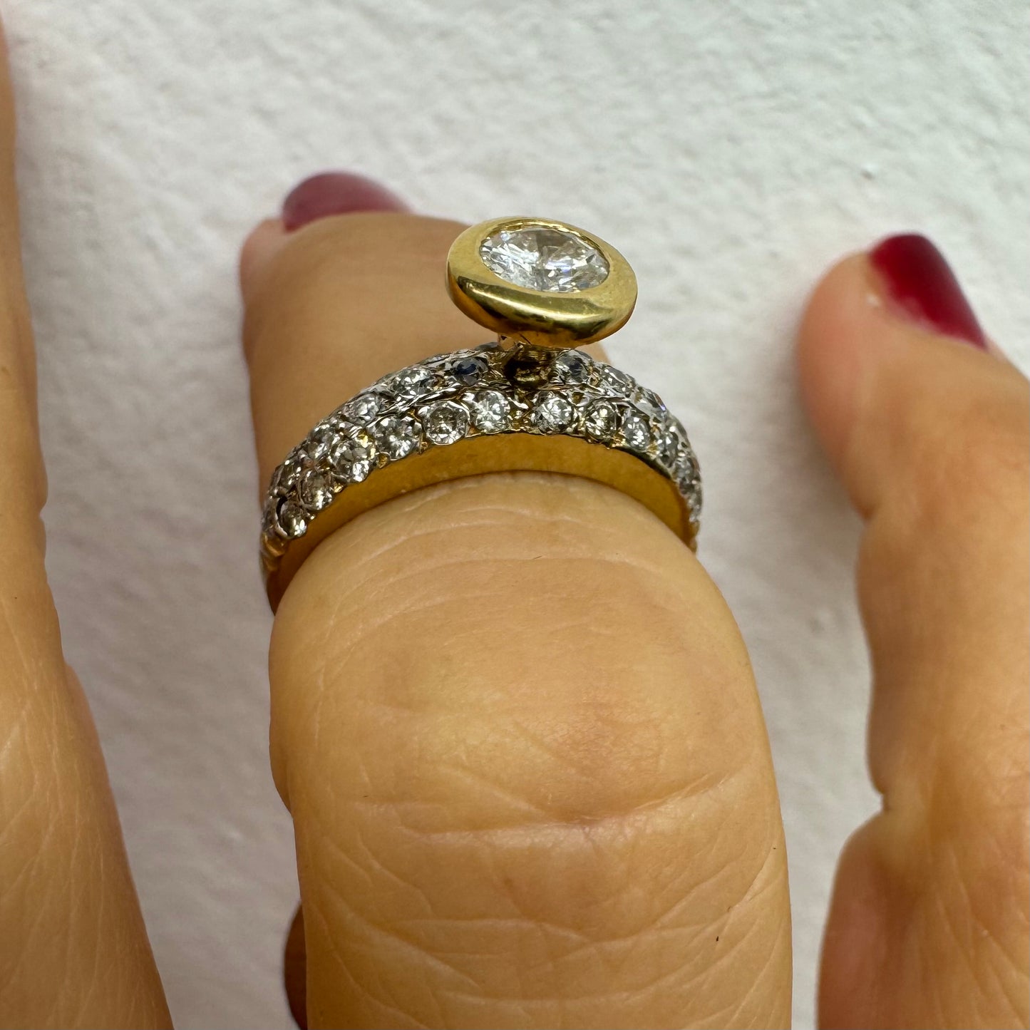 טבעת זהב צהוב 14 קראט משובצת יהלום עגול ויהלומים נוספים על הרצועה.