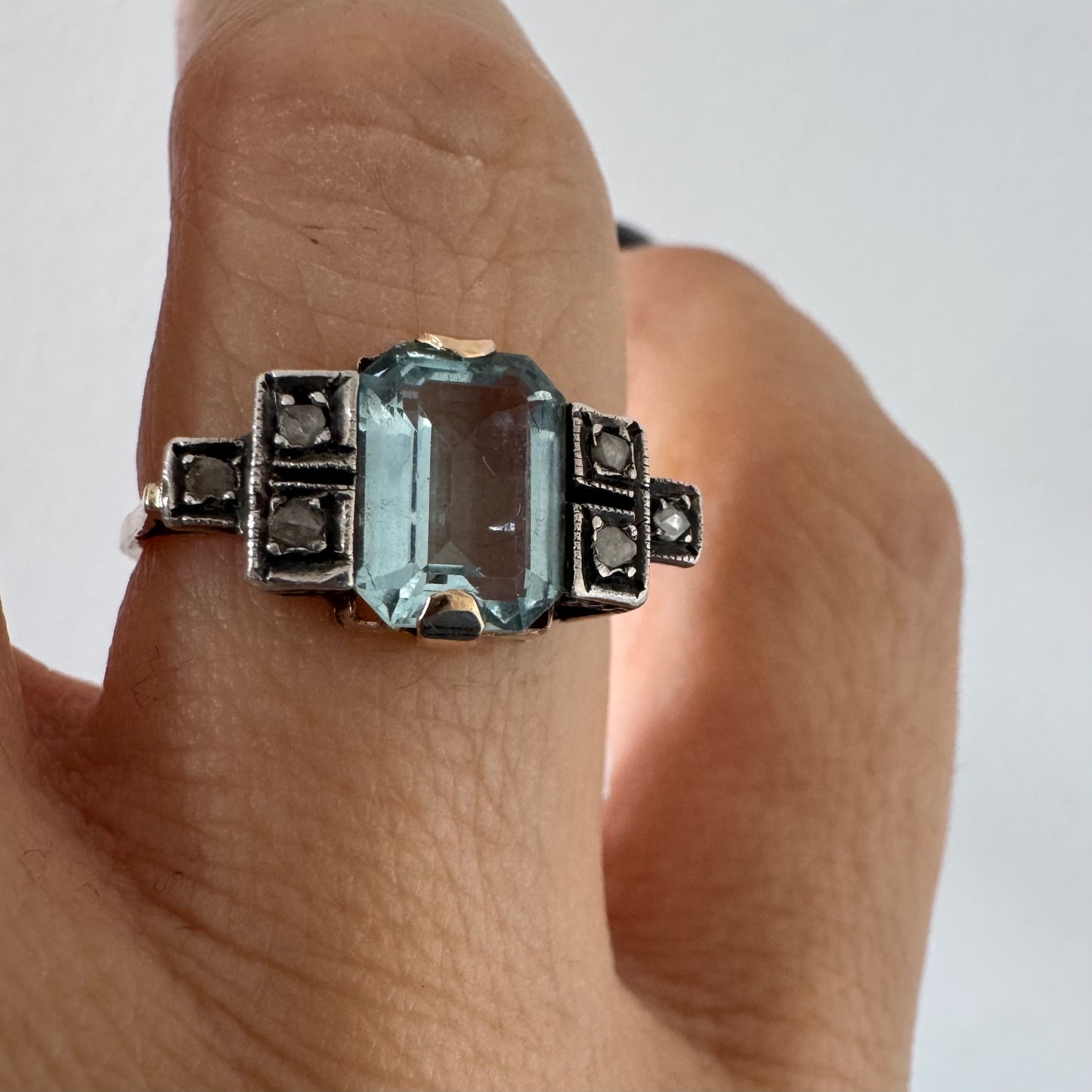 טבעת עתיקה מזהב 14 קראט, משובצת אבן אקוומרין מרכזית בחיתוך מלבני ויהלומים.