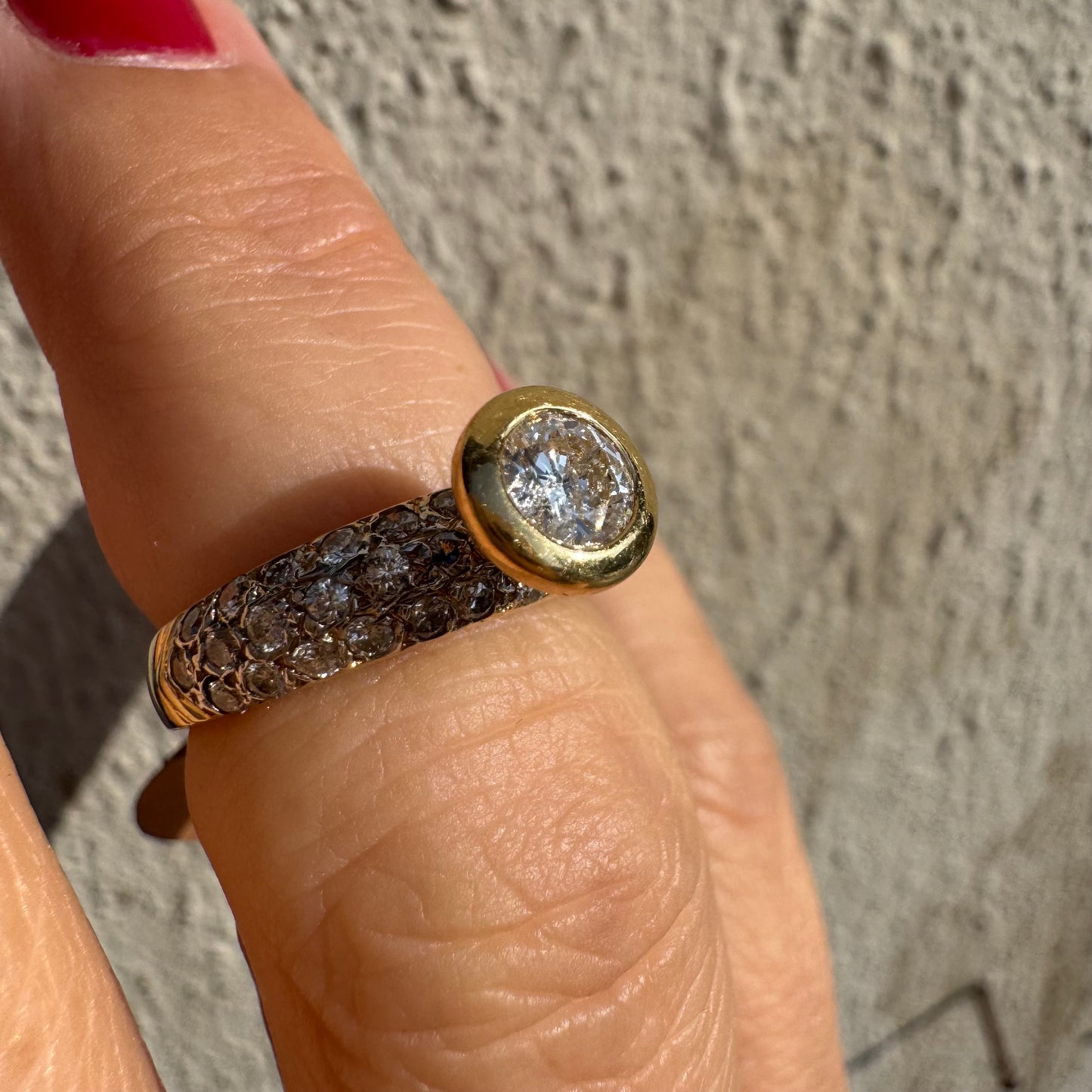 טבעת זהב צהוב 14 קראט משובצת יהלום עגול ויהלומים נוספים על הרצועה.