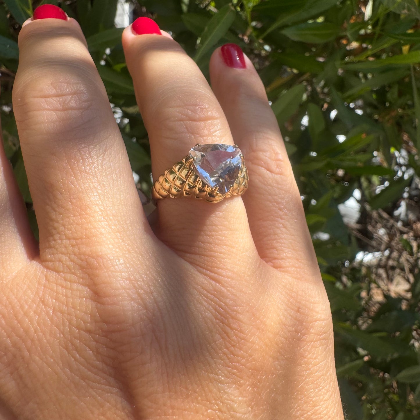 10K gold ring featuring a large, triangular-cut transparent gemstone set in a bold textured band