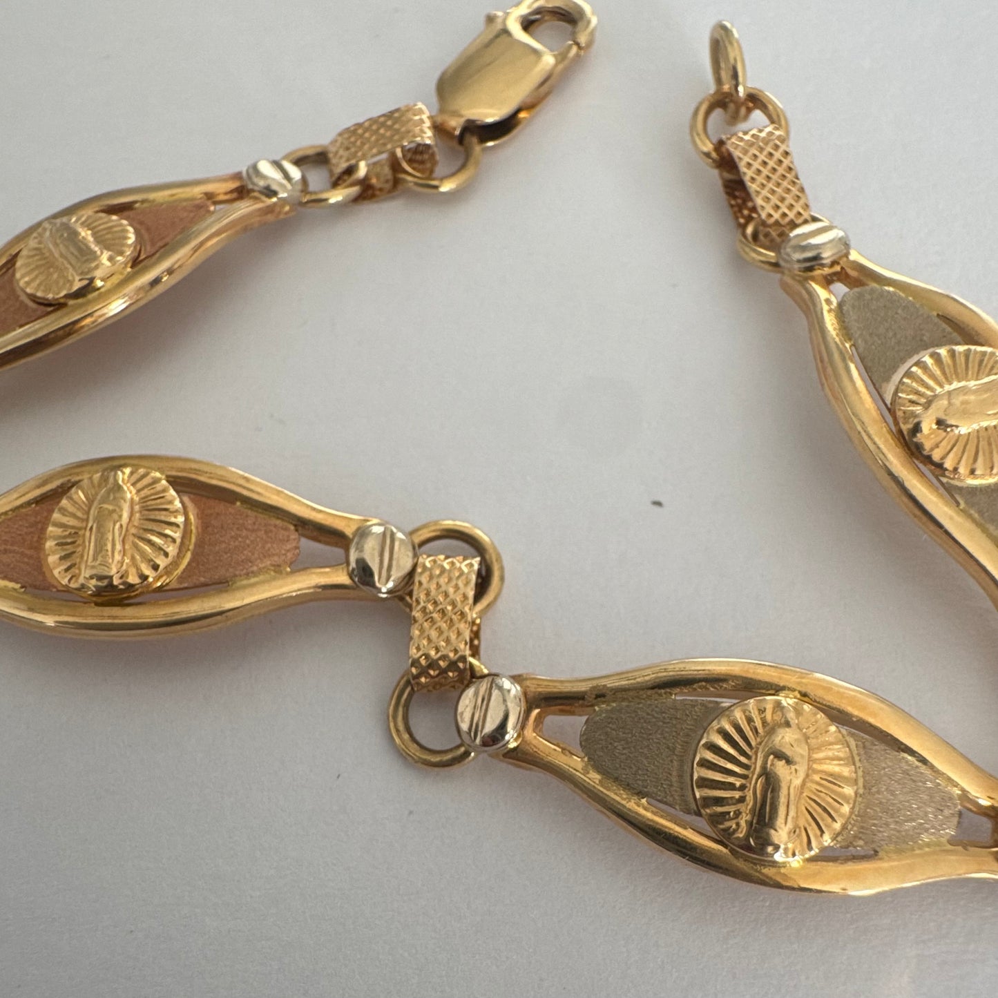 צמיד זהב צהוב 14 קראט עם אלמנט מרכזי בדמות מריה הקדושה, מוקפת קרני אור.