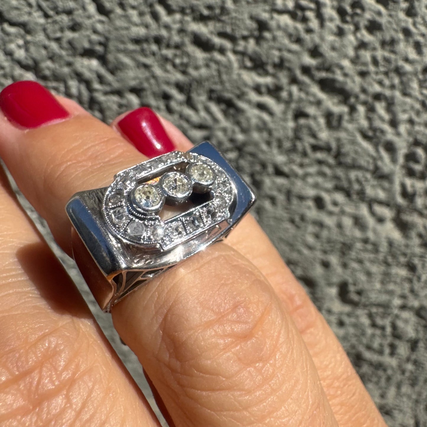 18K gold ring featuring three round 3 Diamonds in the center, framed by a rectangular halo of smaller Diamonds.