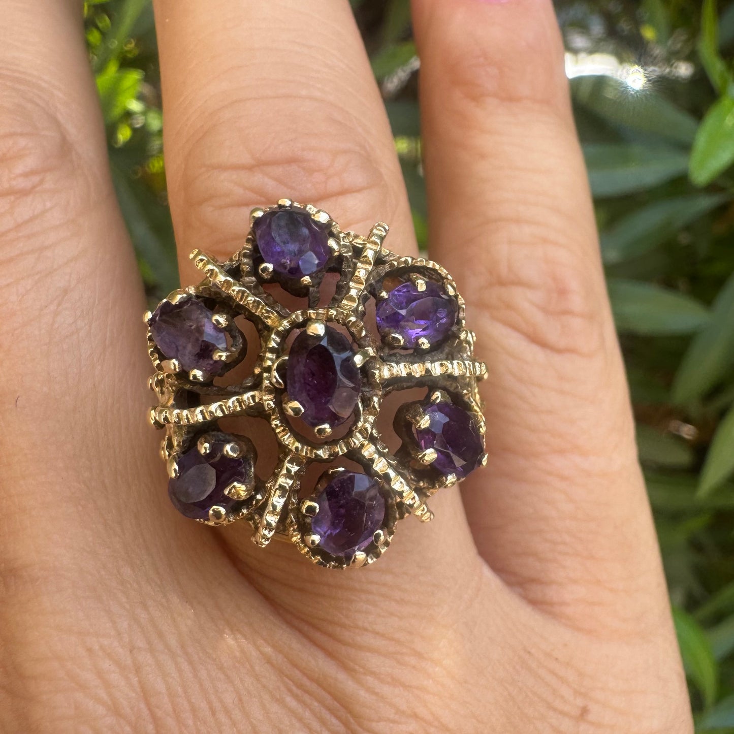 14K gold ring set with deep purple amethysts in an ornate floral design.