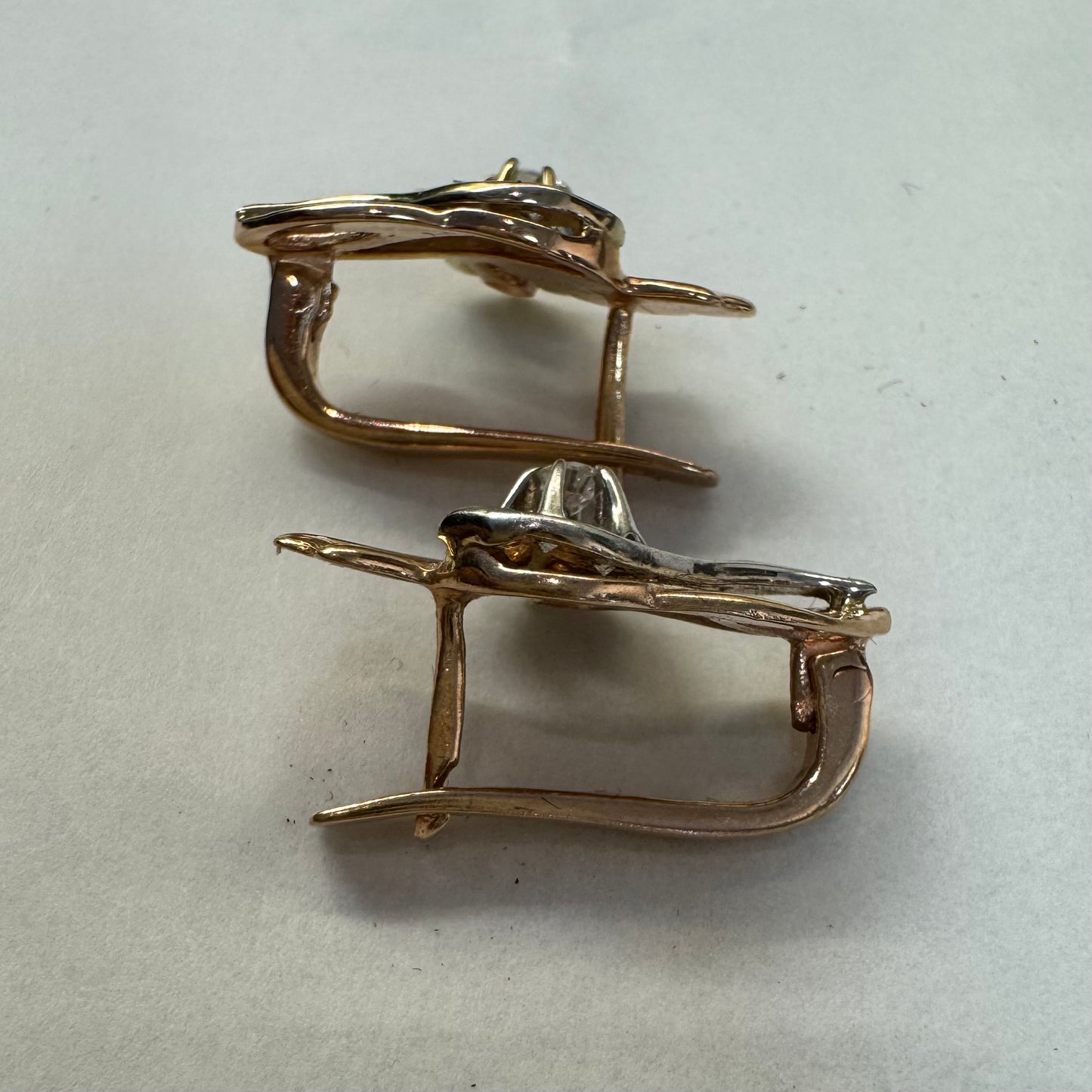 עגילי זהב 14 קראט בעיצוב מתעגל ואלגנטי המשובצים יהלומים נוצצים .