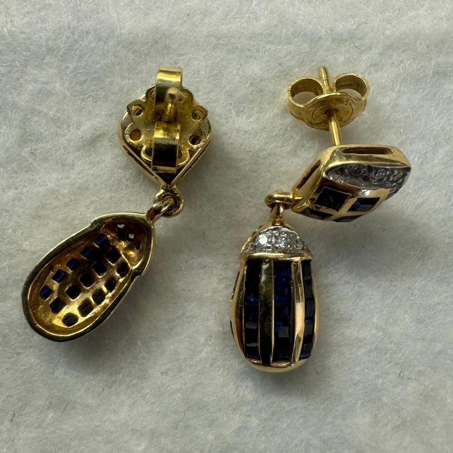 עגילי זהב צהוב 18 קראט תלויים, משובצים אבני ספיר כחולות בגוון כחול עמוק בעיצוב גיאומטרי, בשילוב יהלומים מנצנצים