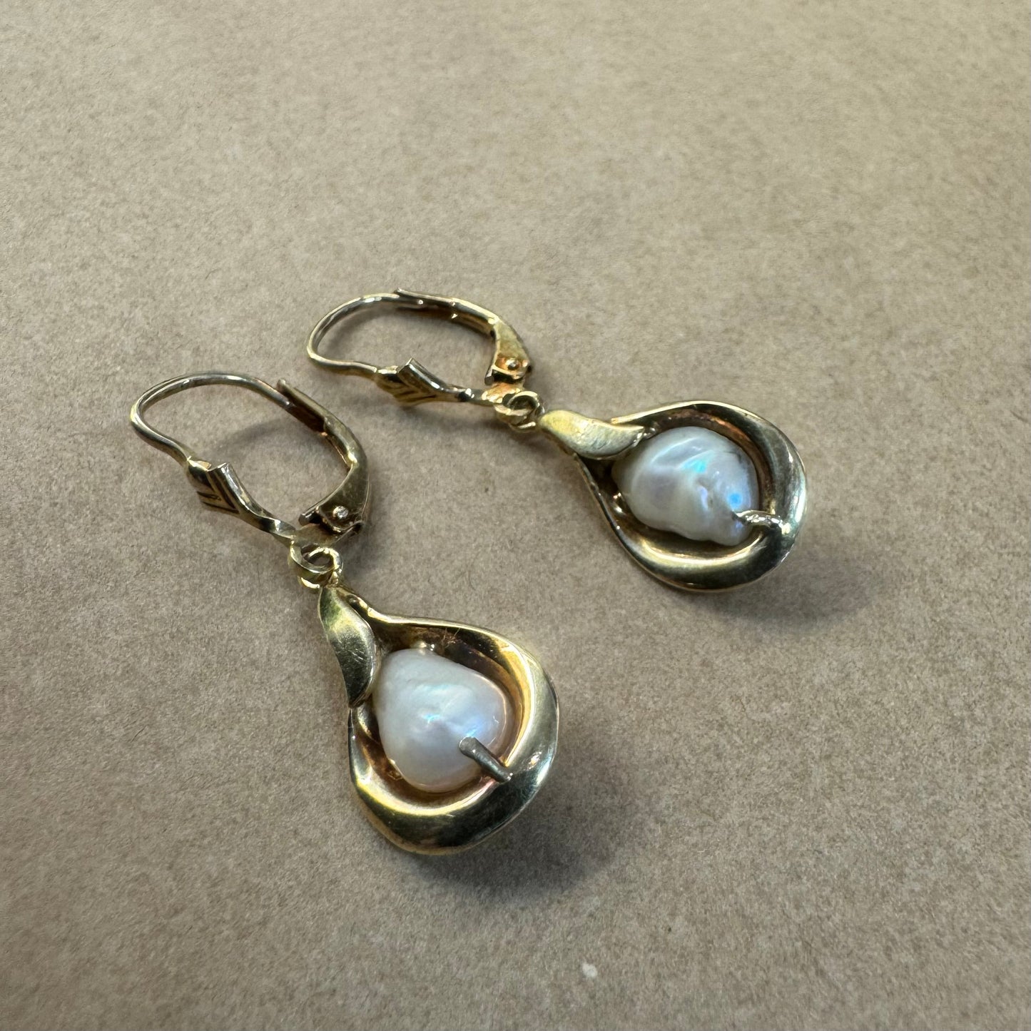 עגילי זהב צהוב 14 קראט משובצים פניני בארוק בעיצוב נוזלי ורך שמדגיש את היופי הטבעי של הפנינה