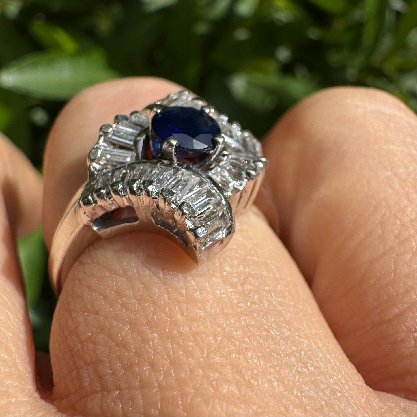 14K gold ring set with a round deep blue sapphire at the center, surrounded by baguette cut Diamonds