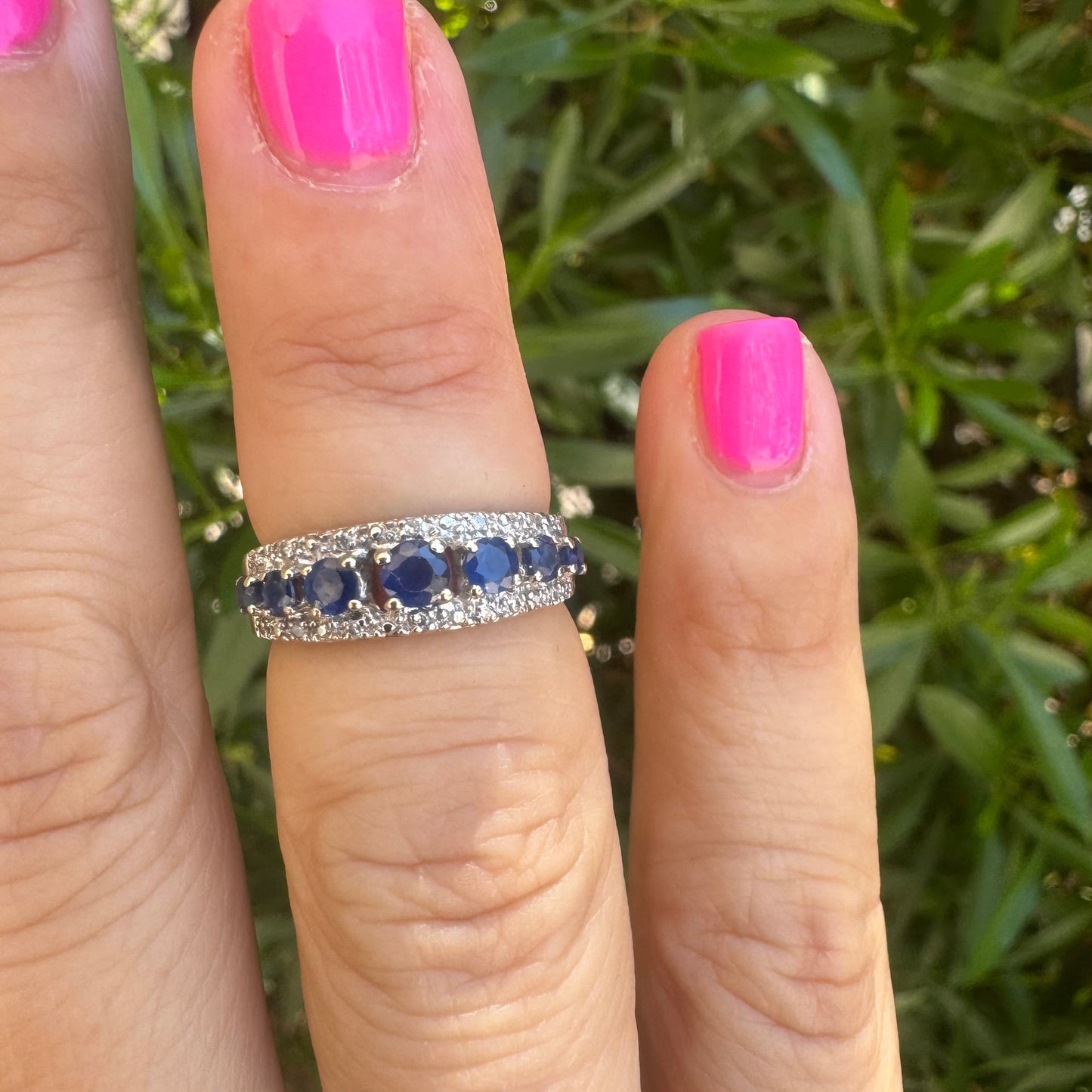 18K gold ring set with deep blue sapphires in a classic round cut, framed by two shimmering rows of brilliant Diamonds.