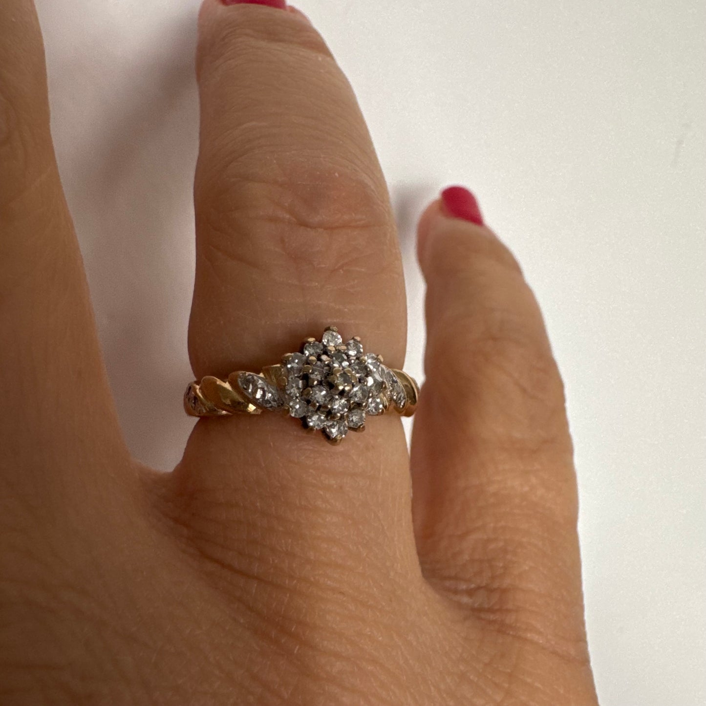 טבעת זהב צהוב 9 קראט משובצת יהלומים בעיצוב פרח עדין.