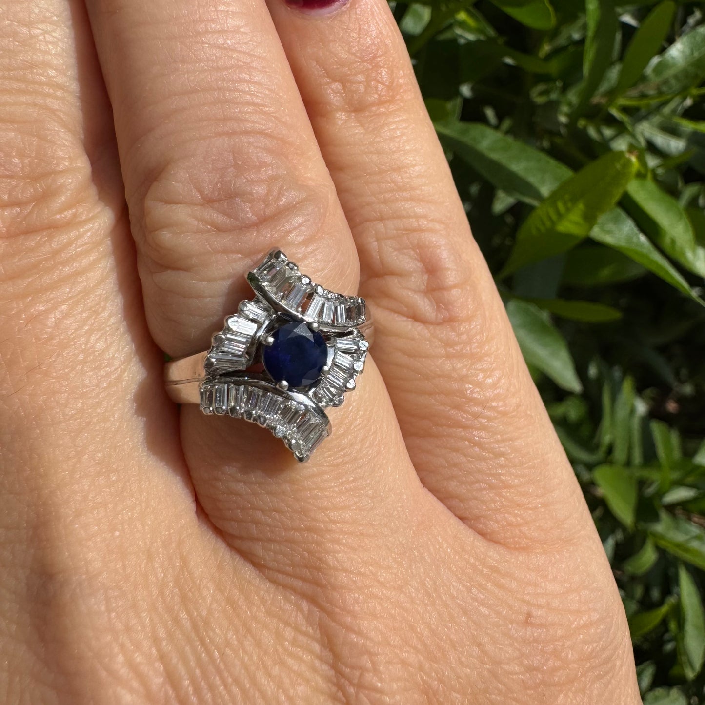 14K gold ring set with a round deep blue sapphire at the center, surrounded by baguette cut Diamonds