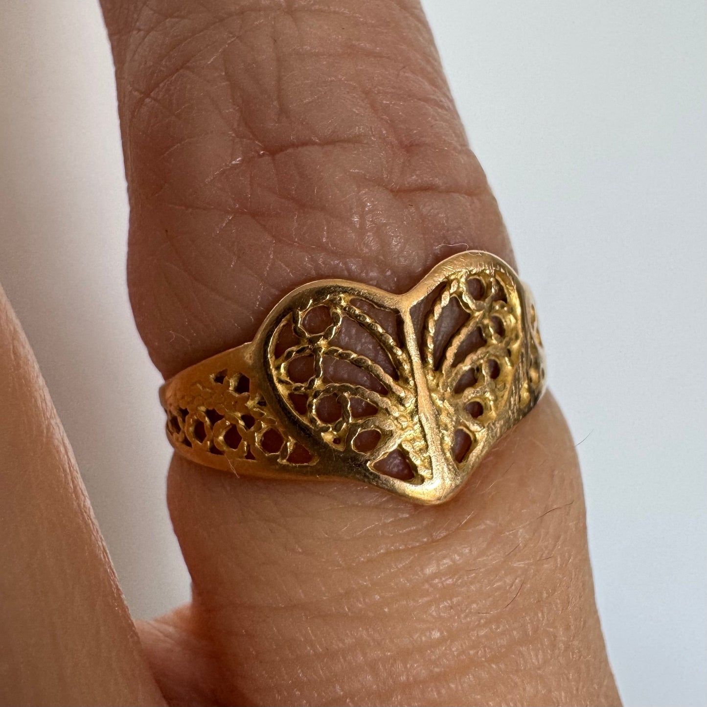 טבעת זהב 21 קראט בעיצוב לב עדין עם עבודת פיליגרן פתוחה.