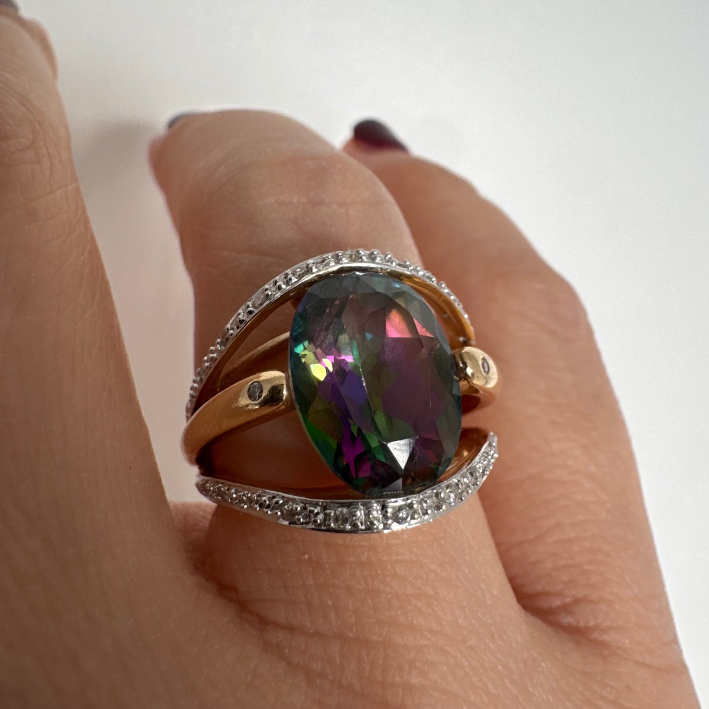 14K gold ring set with an oval Mystic Topaz