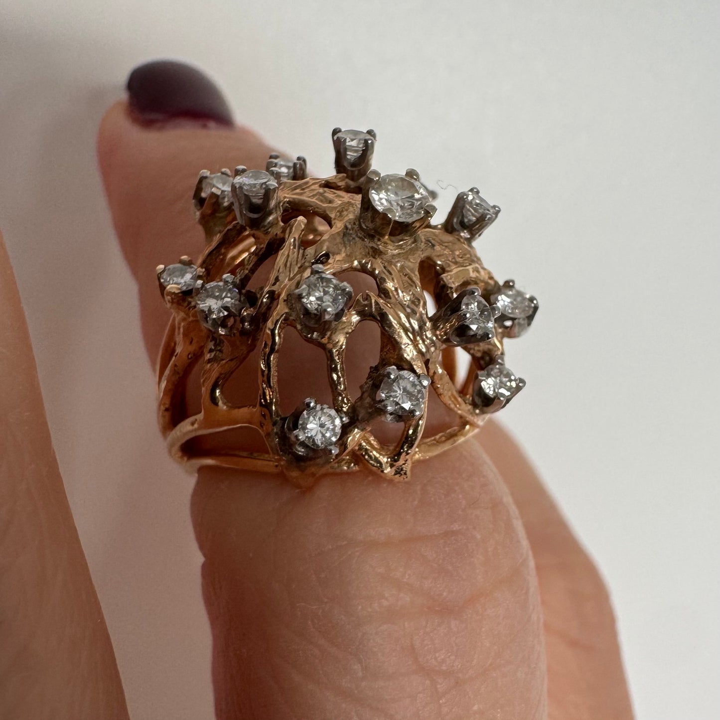 טבעת זהב 10 קראט בעיצוב פיסולי פתוח, משובצת יהלומים במבנה עגול דינמי.