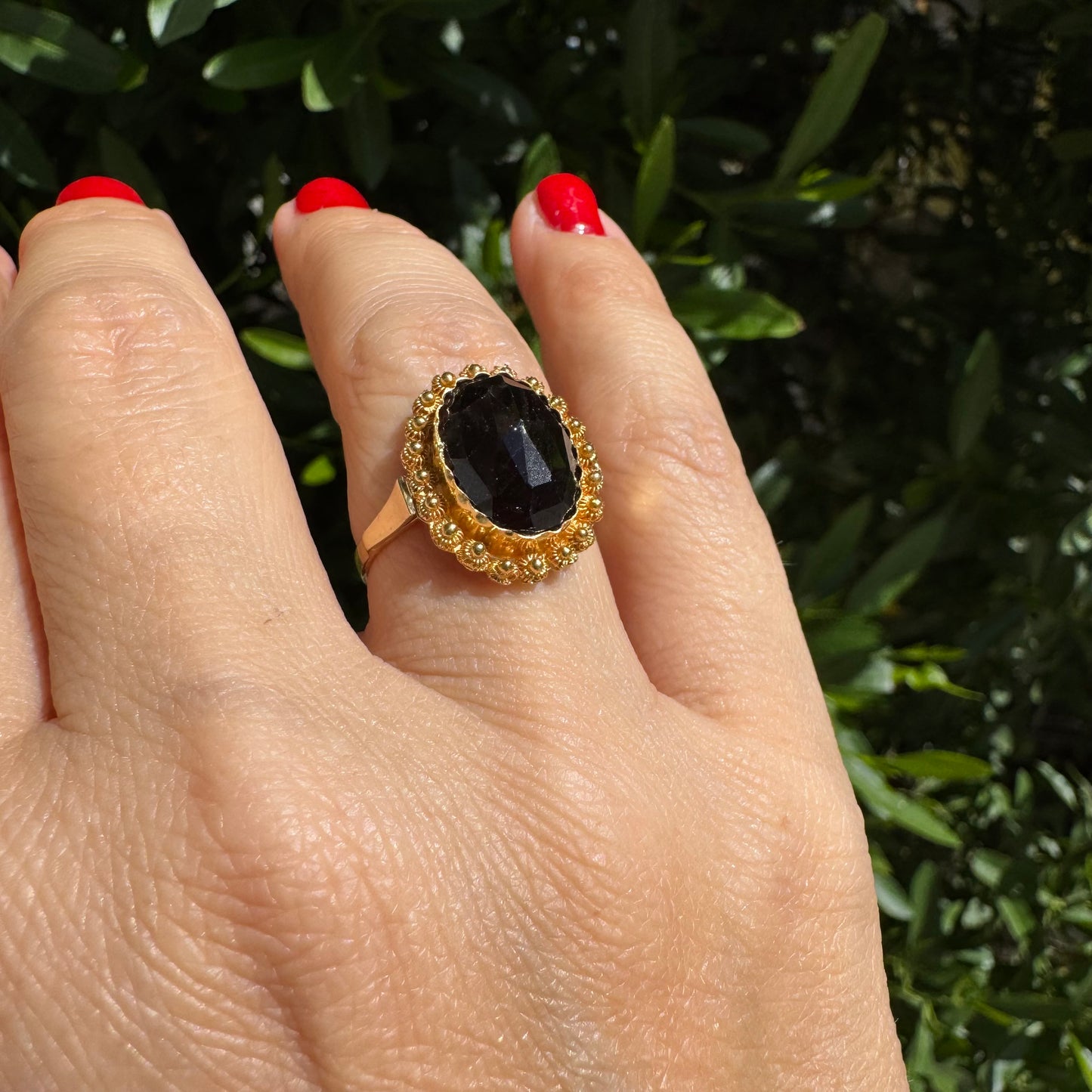 14K gold ring set with a large Garnet surrounded by delicate gold details