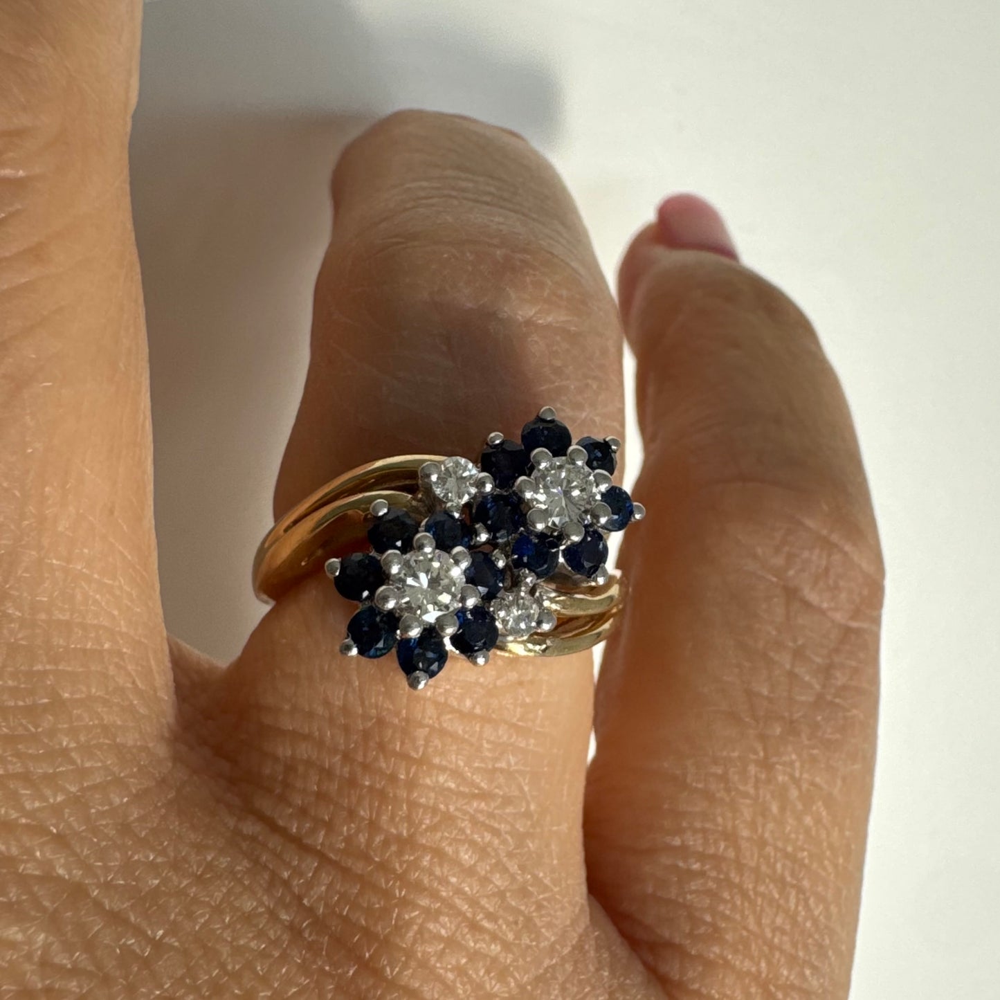 טבעת זהב צהוב 14 קראט משובצת אבני ספיר ויהלומים בעיצוב פרחים כפול.