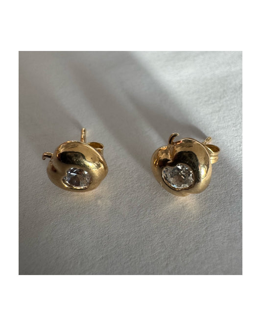 עגילי זהב 14 קראט צמודים לאוזן בצורת תפוח, בעיצוב פיסולי ורך עם אבן שקופה משובצת במרכז.