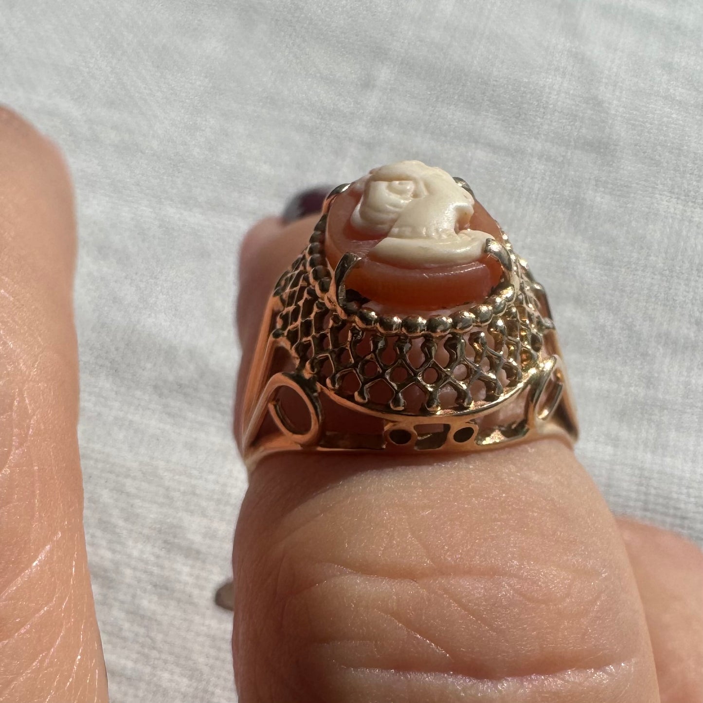 18K gold ring featuring a hand-carved Cameo of a delicate female profile in ivory tones on a warm Coral background.