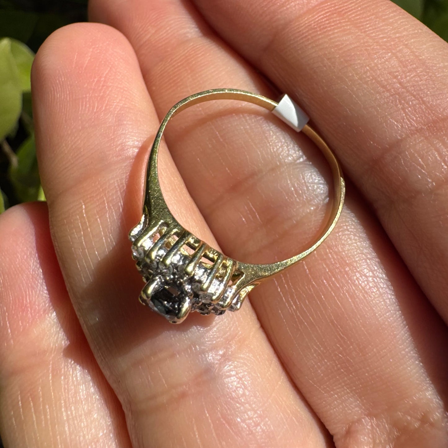 14K gold ring set with an oval blue Sapphire surrounded by sparkling Diamonds