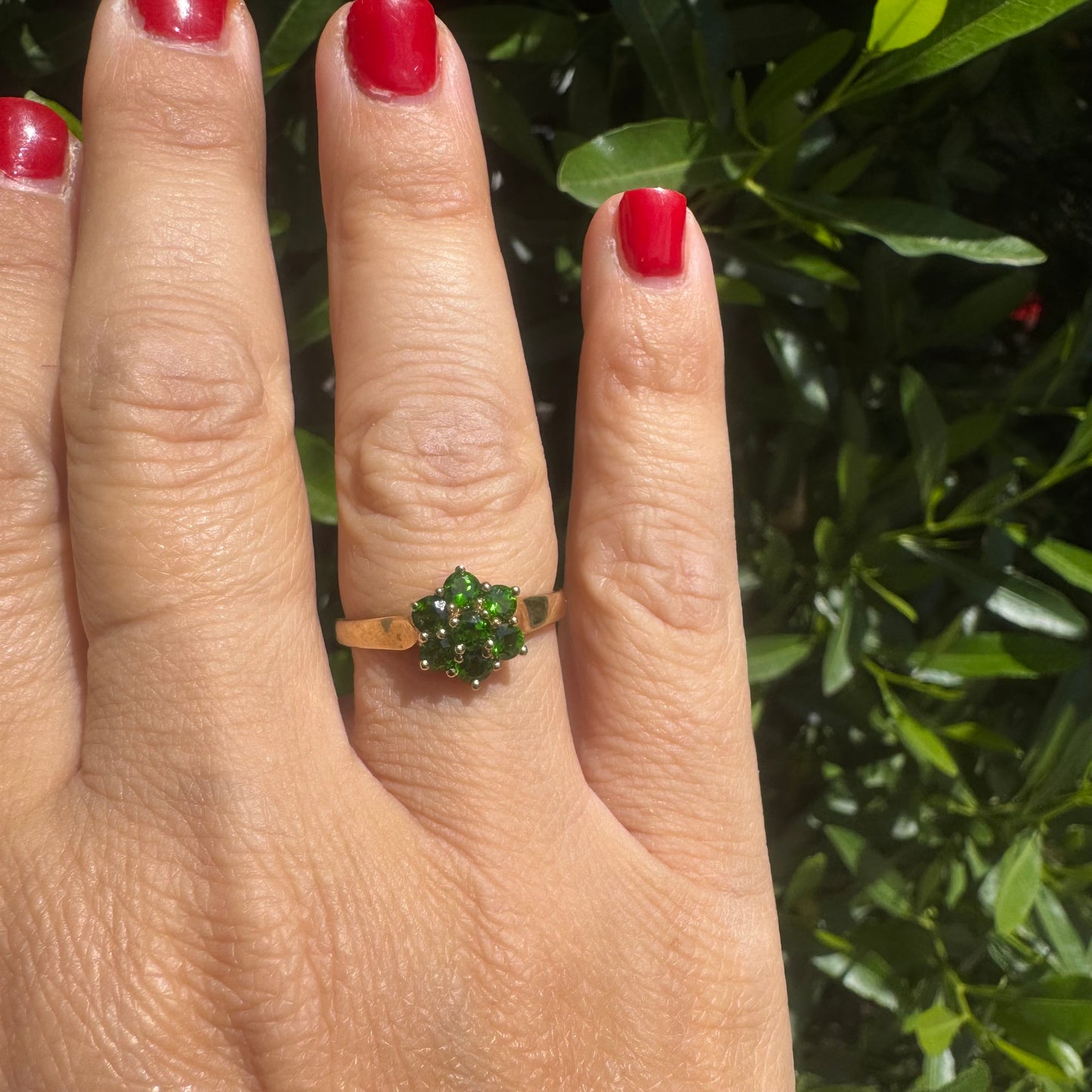 10K gold ring set with vivid green gemstones in a delicate floral cluster