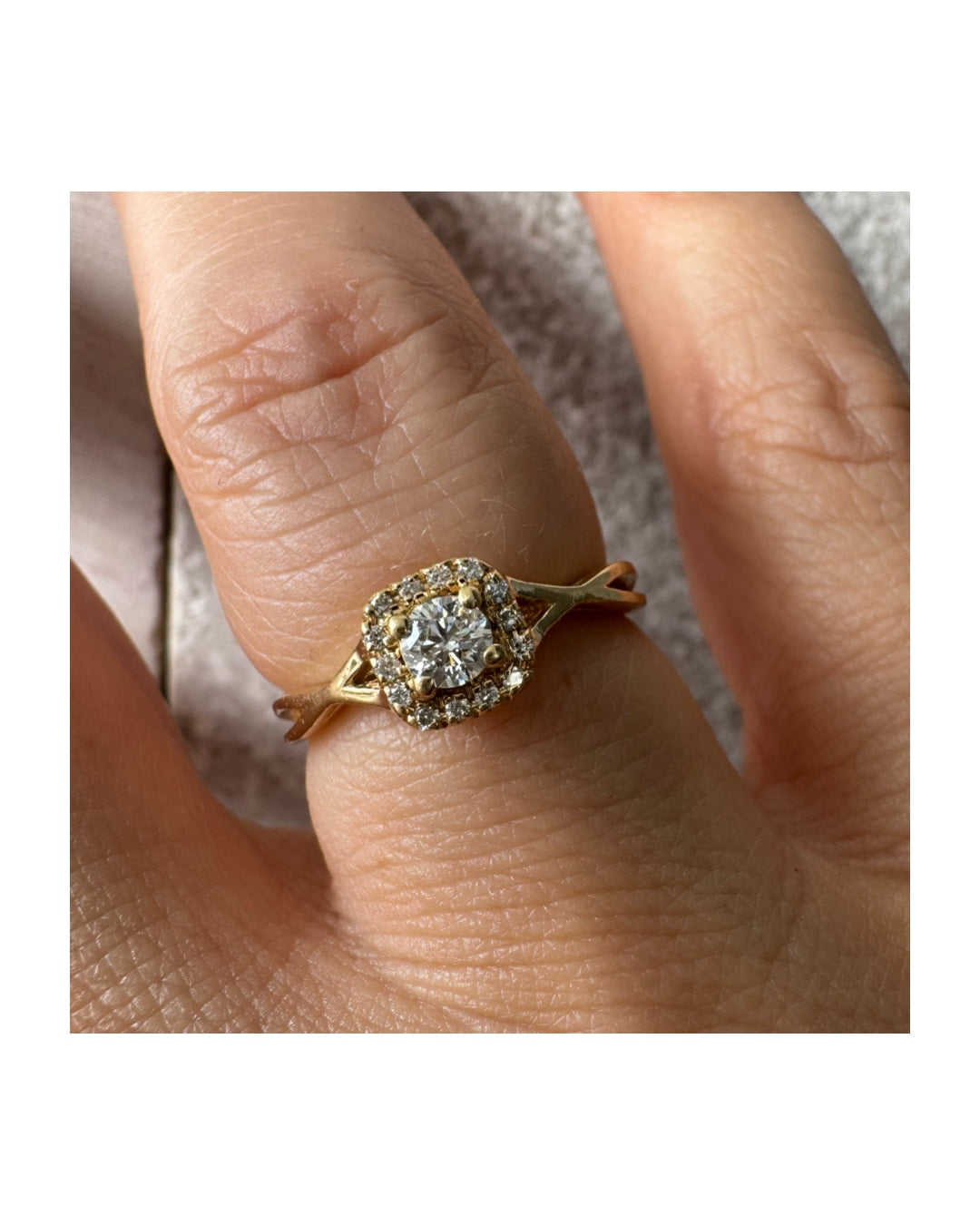 טבעת זהב 14 קראט משובצת יהלום מרכזי עגול ומבריק, מוקף הילה עדינה של יהלומים המעצימים את הברק