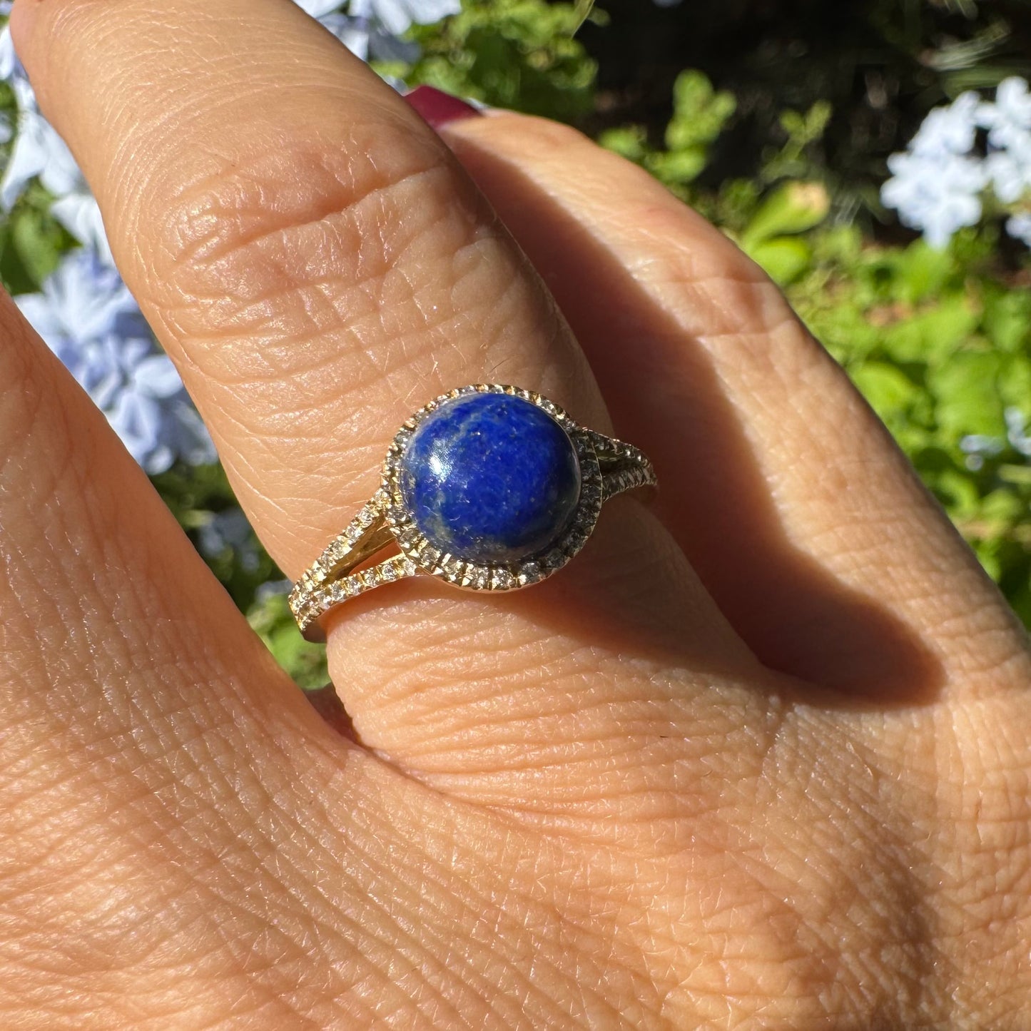 14K gold ring set with a round Lapis Lazuli gemstone, surrounded by a delicate halo of sparkling Diamonds.