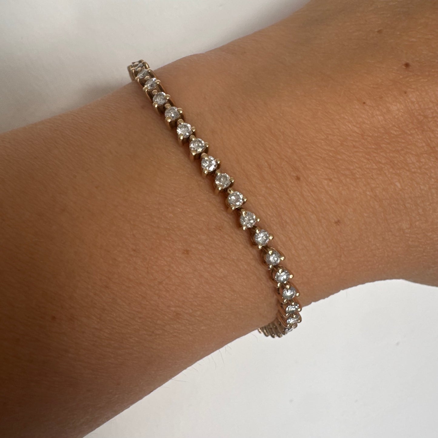 צמיד טניס קלאסי מזהב 14 קראט, משובץ שורה רציפה של יהלומים עגולים המעניקים ברק עדין ואלגנטי.