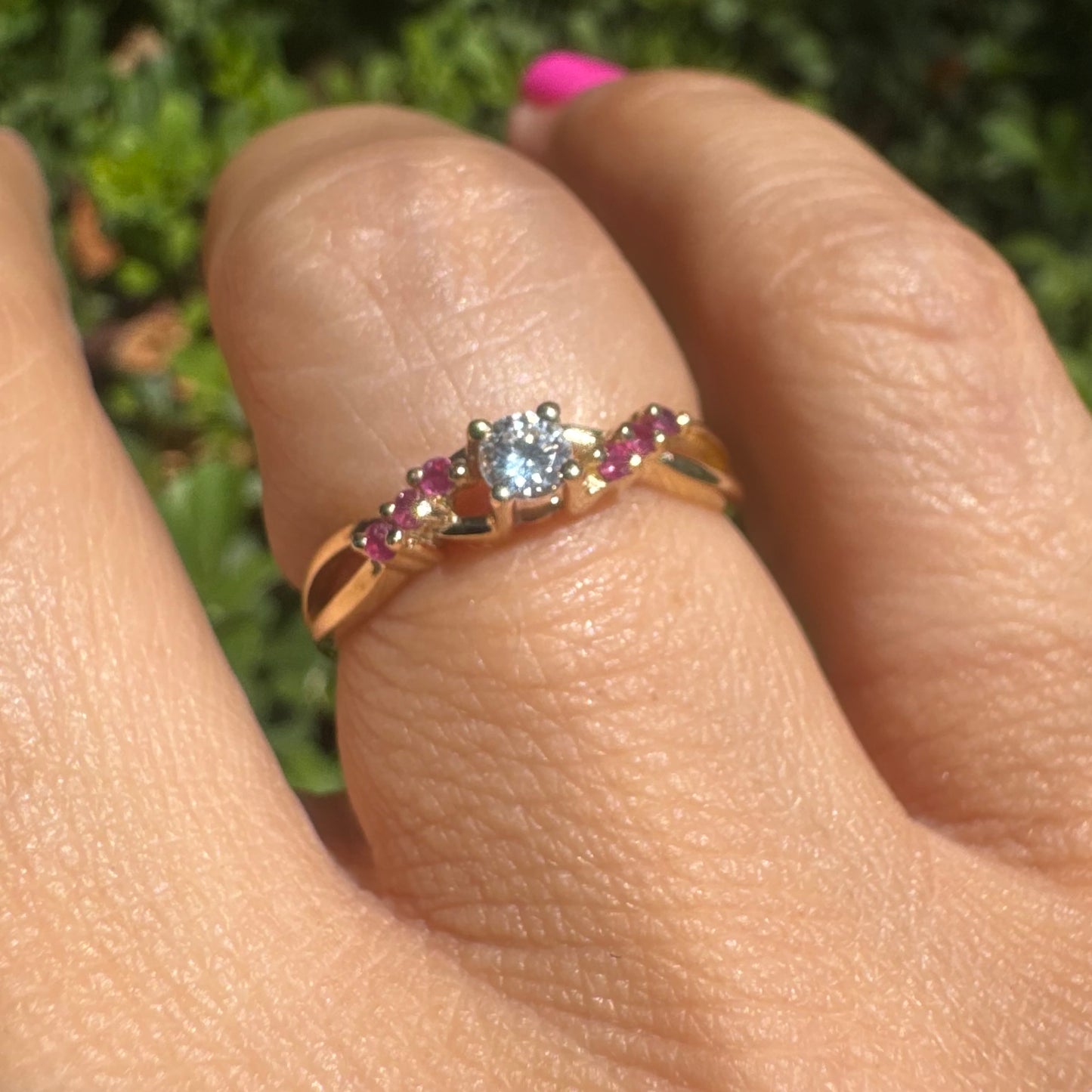 טבעת זהב צהוב 14 קראט, עדינה משובצת יהלום עגול מרכזי, משובצת באבני רובי לאורך החישוק.