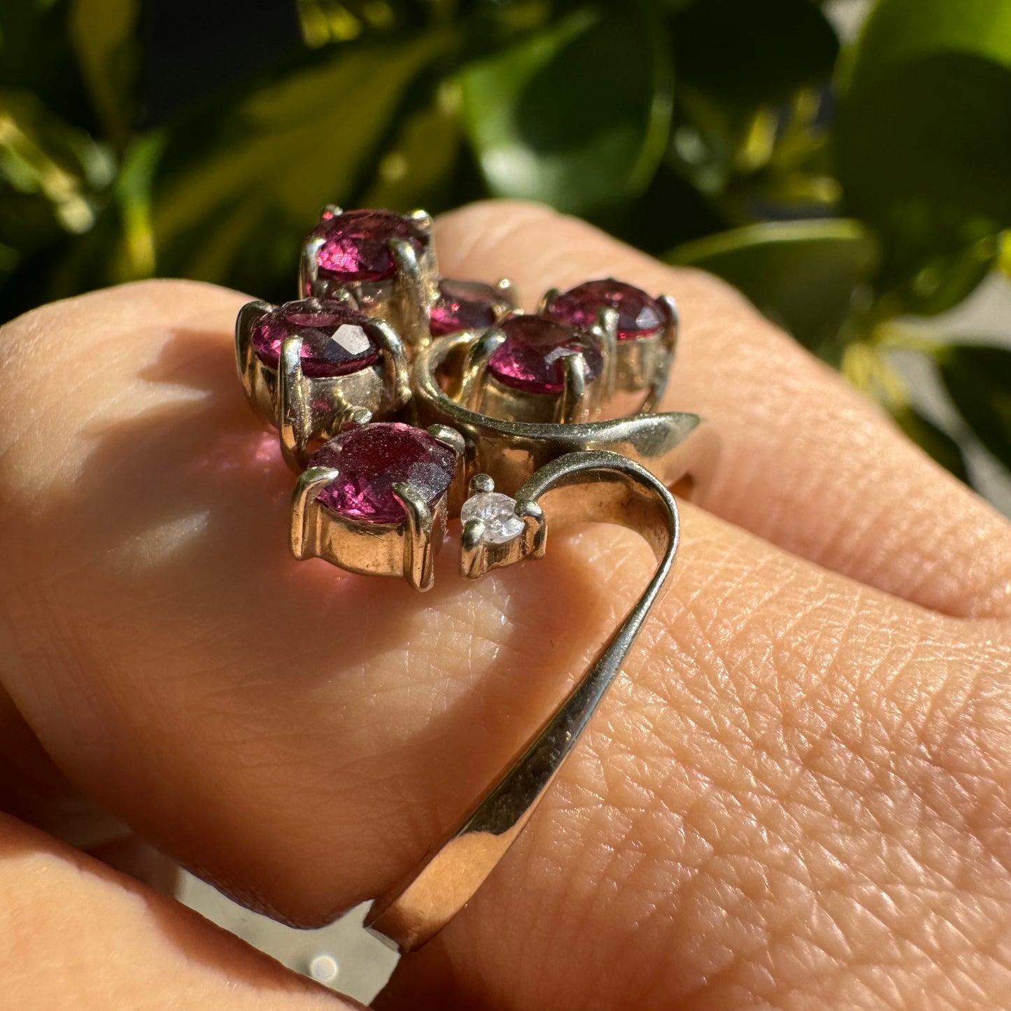 14K gold ring with an open, flowing design, set with multiple pink Tourmaline stones and accented by a Diamond