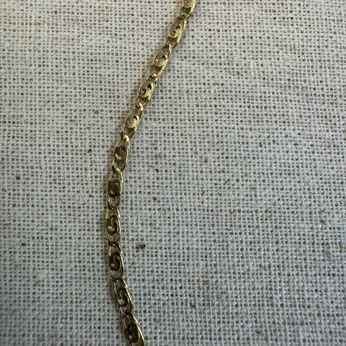 14K gold necklace featuring oval-shaped links with a subtle decorative pattern.