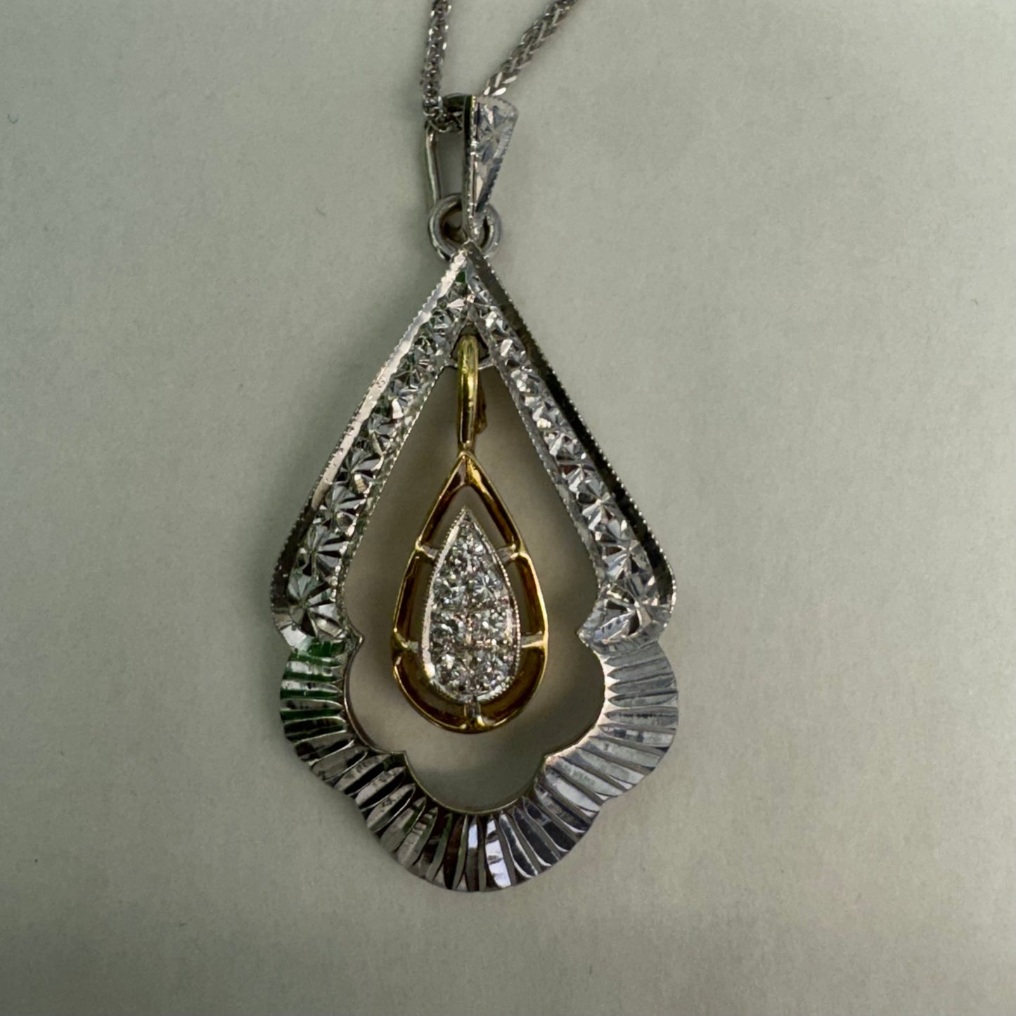 14K white and yellow gold pendant in a unique geometric design set with Diamonds