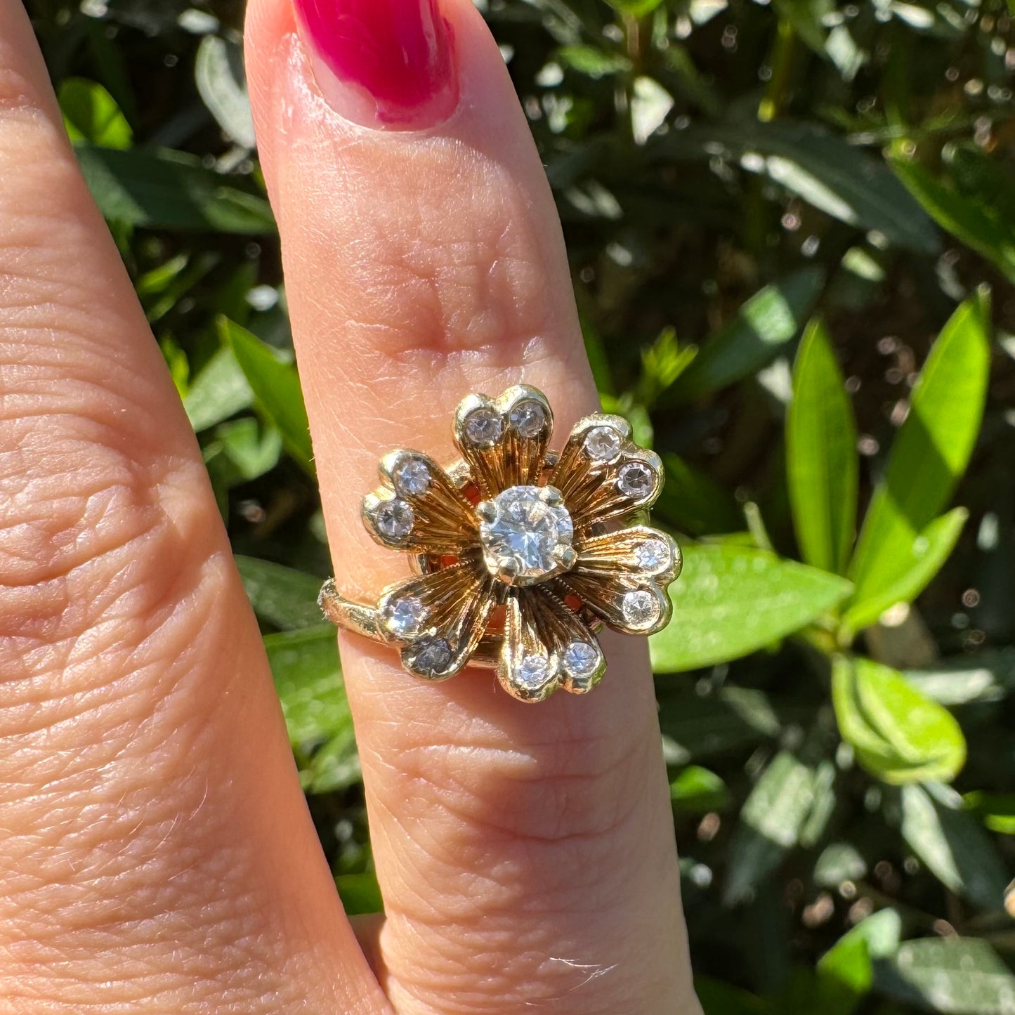 14K gold ring in a floral design, set with sparkling Diamonds at the center and around the petals.