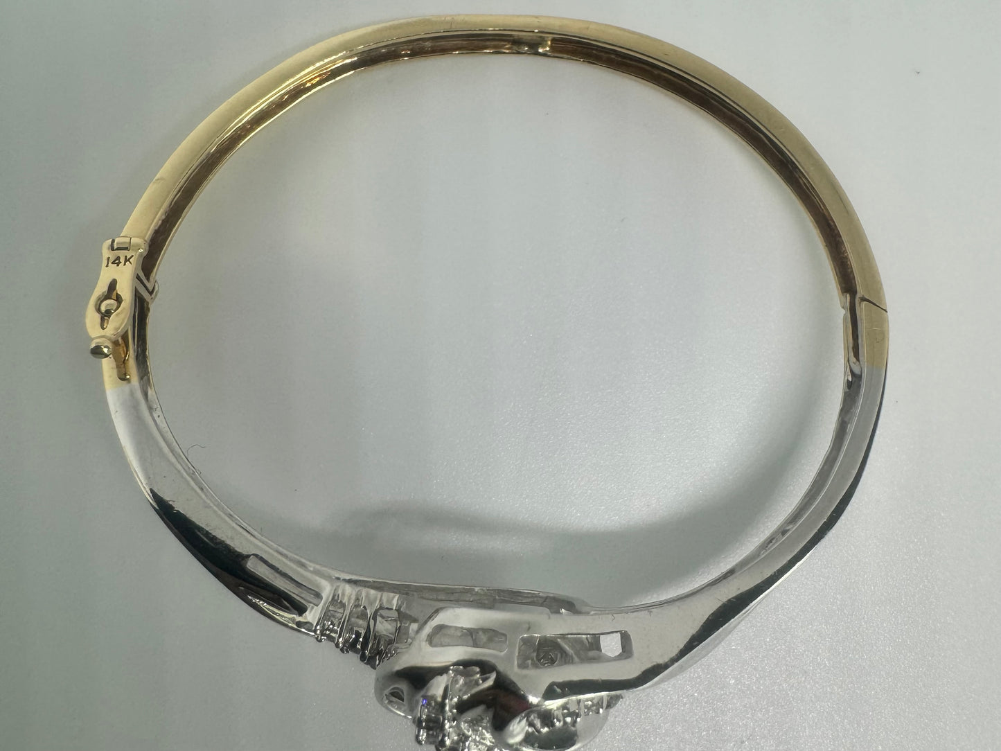 צמיד מרהיב מזהב לבן 14 קראט, בעיצוב גלים דינמי המשובץ בשיבוץ מרוכב של יהלומים עגולים ובחיתוך באגט.