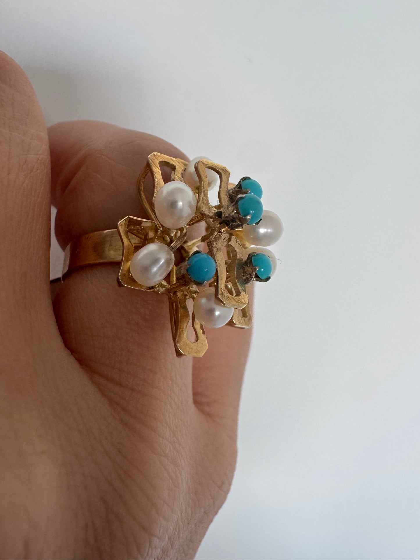 טבעת זהב צהוב 14 קראט משובצת פנינים עגולות ואבני טורקיז ליצירת ניגוד מרשים