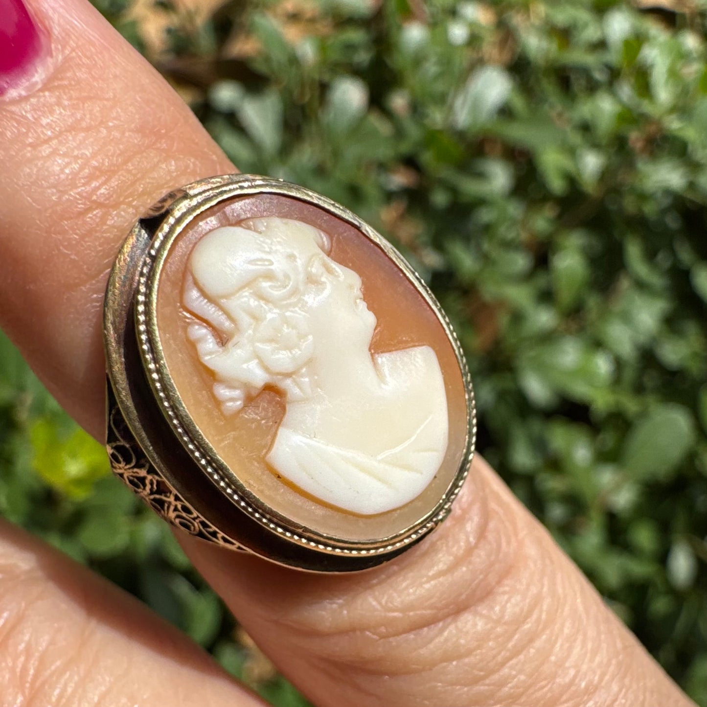 14K gold cameo ring featuring a finely carved portrait of a woman in profile, set in an oval bezel with intricate gold detailing