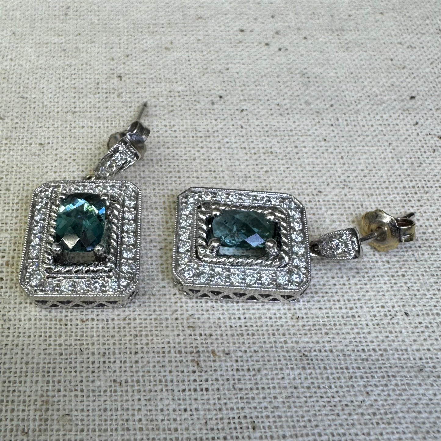 14K gold drop earrings set with emerald-cut Blue Topaz, surrounded by a halo of sparkling Diamonds