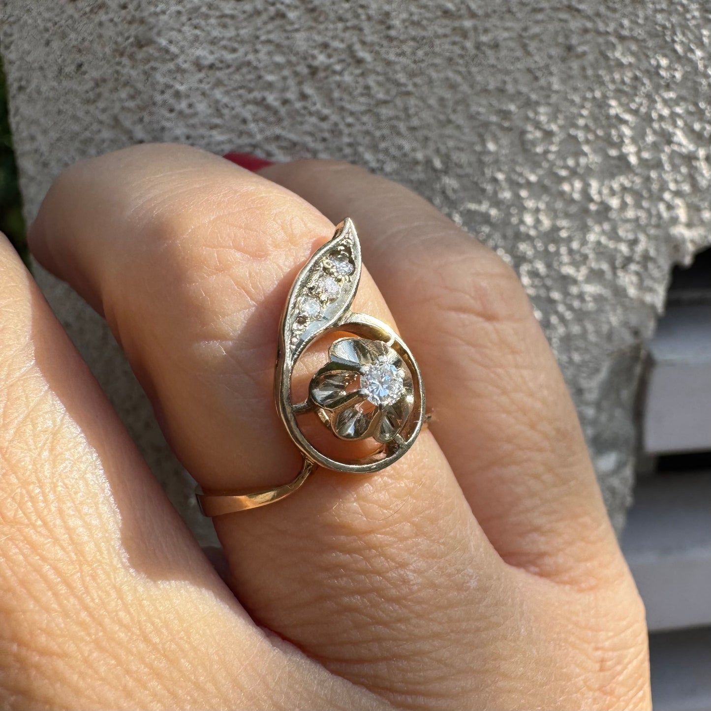 טבעת זהב צהוב 14 קראט בעיצוב פרח עדין המשובצת יהלומים נוצצים .