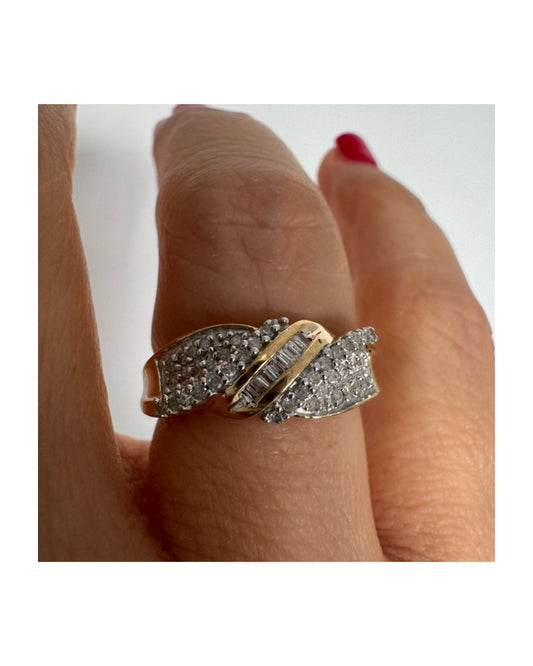 טבעת זהב 10 קראט משובצת יהלומים בחיתוך עגול לצד שורת יהלומי בגט במרכז.