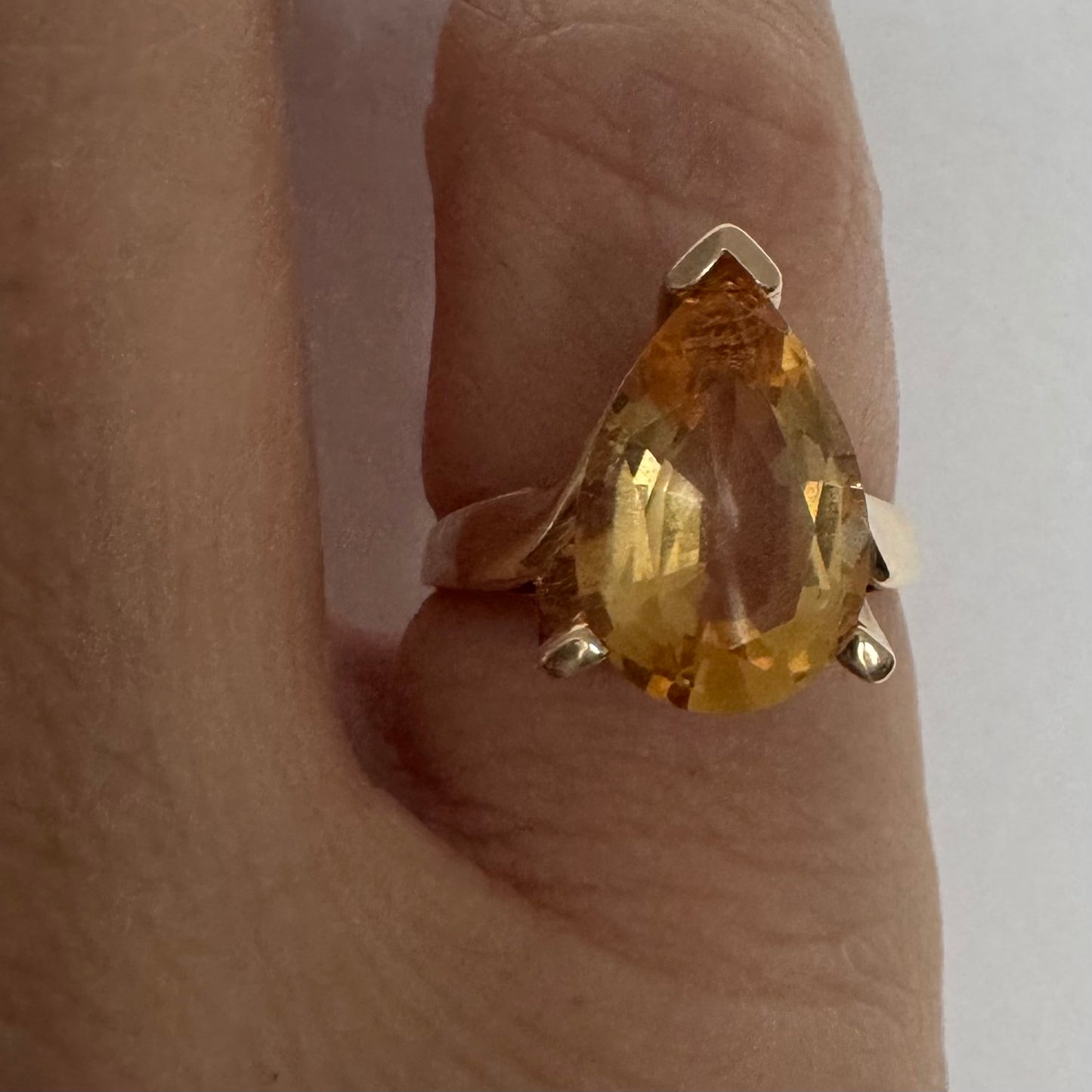 טבעת זהב צהוב 14 קראט משובצת באבן סיטרין גדולה בחיתוך טיפה, עם זהב שמחבק אותה בצורה פתוחה ומודרנית.