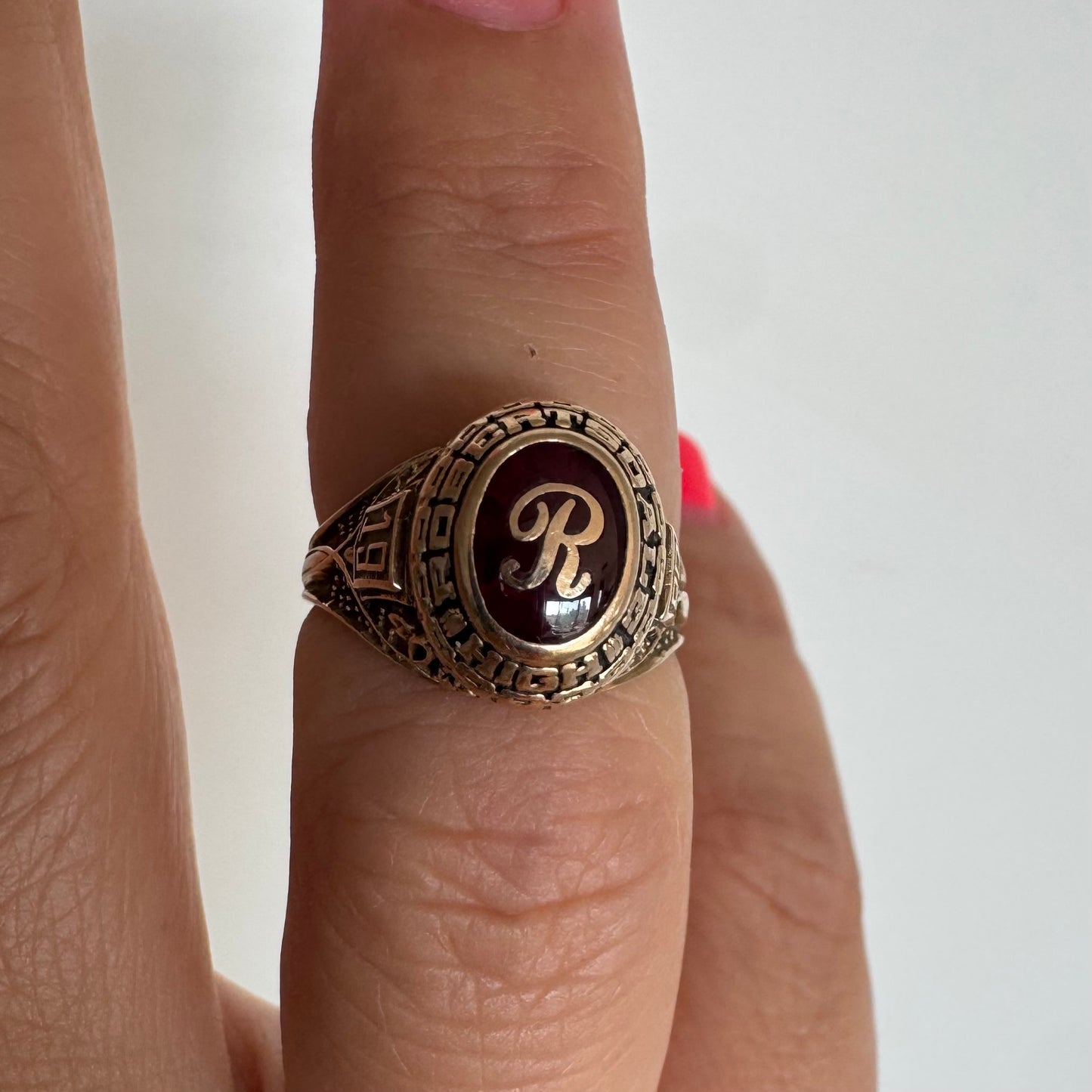 טבעת מחזור (Class Ring) מזהב 10 קראט, בעלת עיצוב אמריקאי קלאסי ובמרכזה אבן אדומה עם האות R עם חריטות וסמלים המעניקים לה אופי ייחודי ונוסטלגי.
