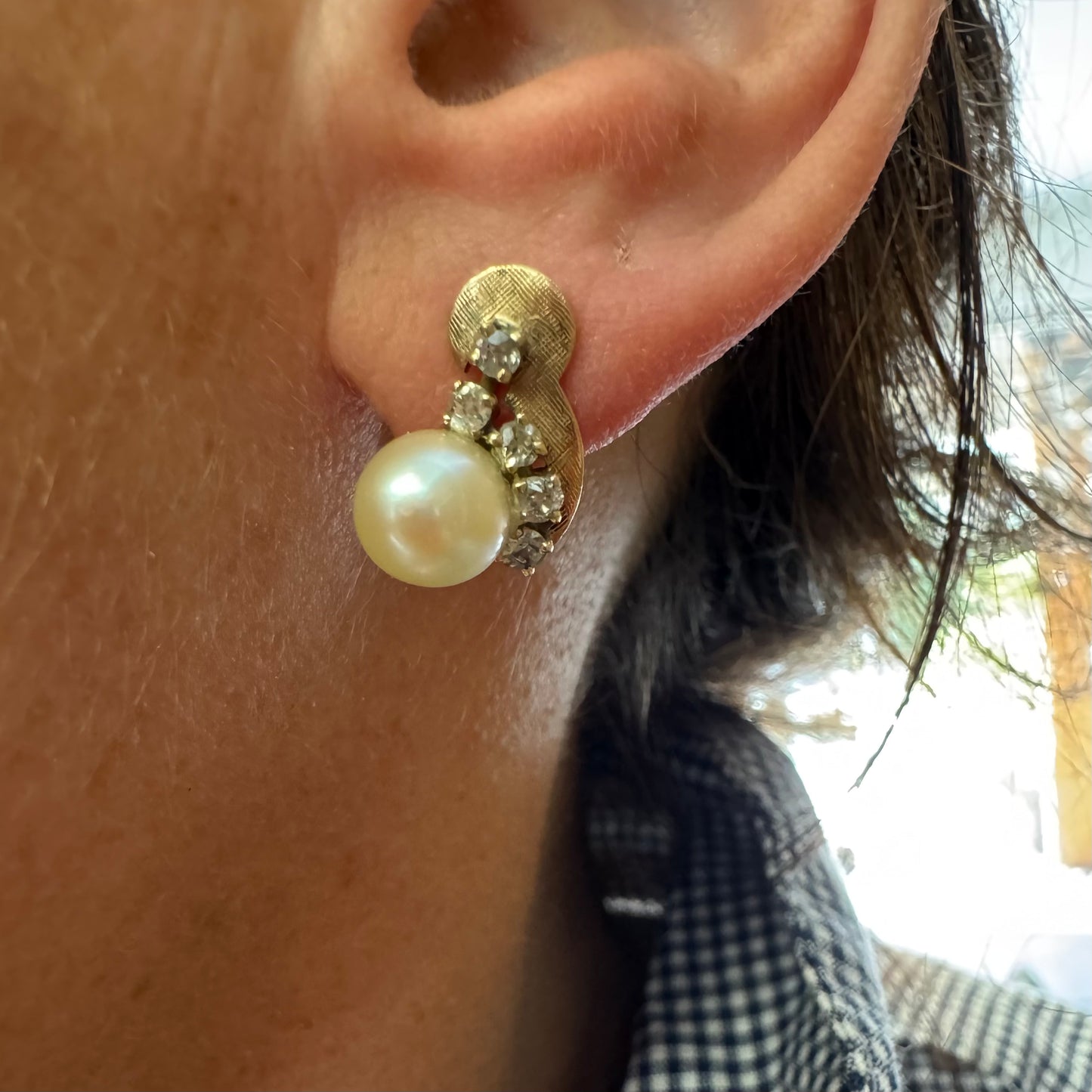 עגילי זהב צהוב 14 קראט, צמודים לאוזן, עשויים זהב בגימור טקסטורלי ומשובצים פנינה עגולה ובשורת יהלומים קטנים בחיתוך עתיק.