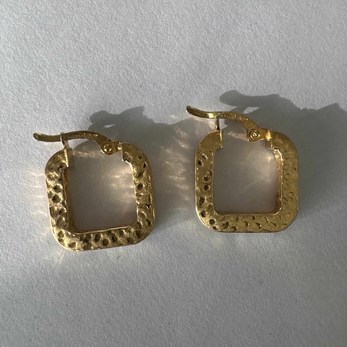 עגילי חישוק מרובעים מזהב 14 קראט בגימור מחוספס ומטאלי. 