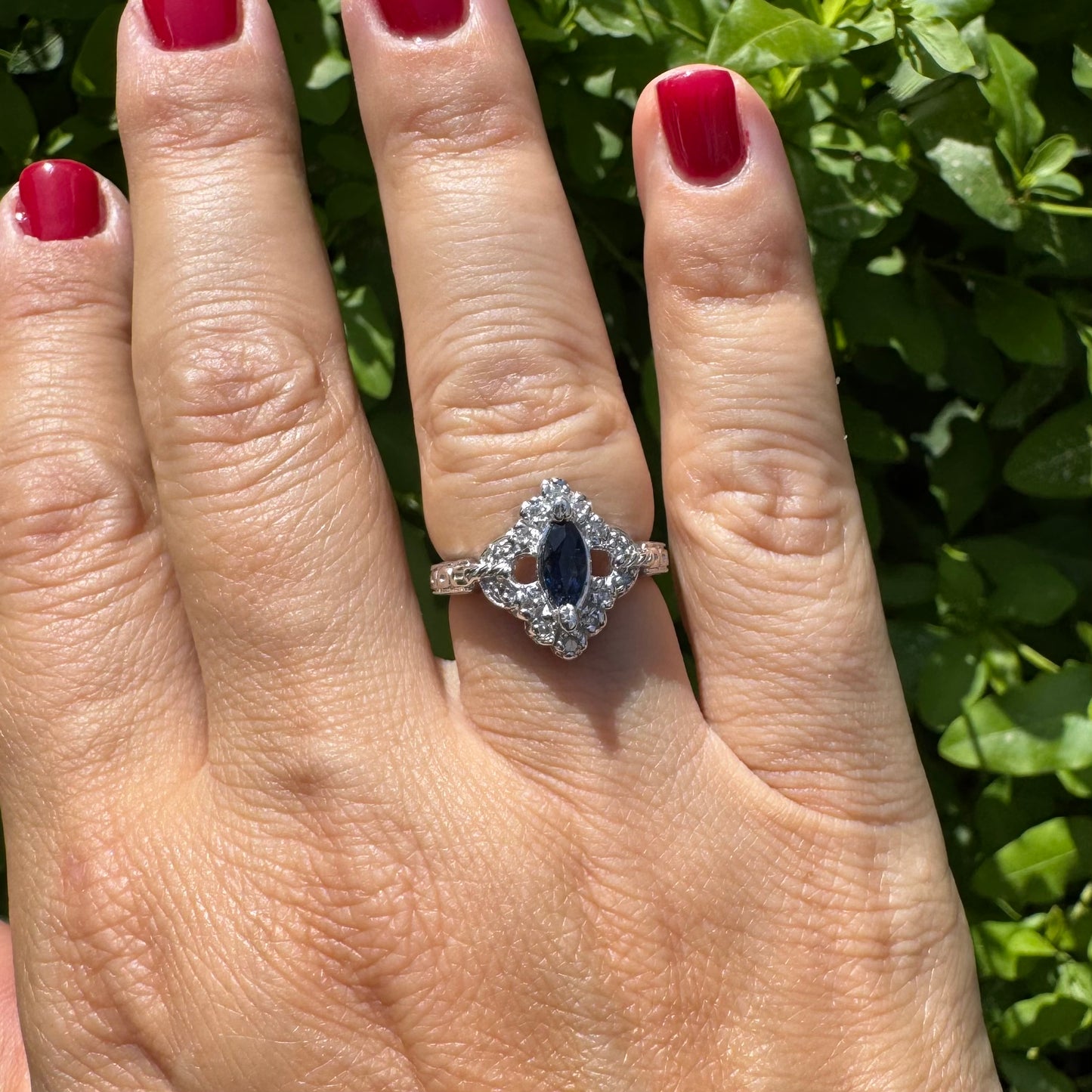 14K gold ring set with a marquise-cut Sapphire at its center, framed by an intricate halo of sparkling Diamonds