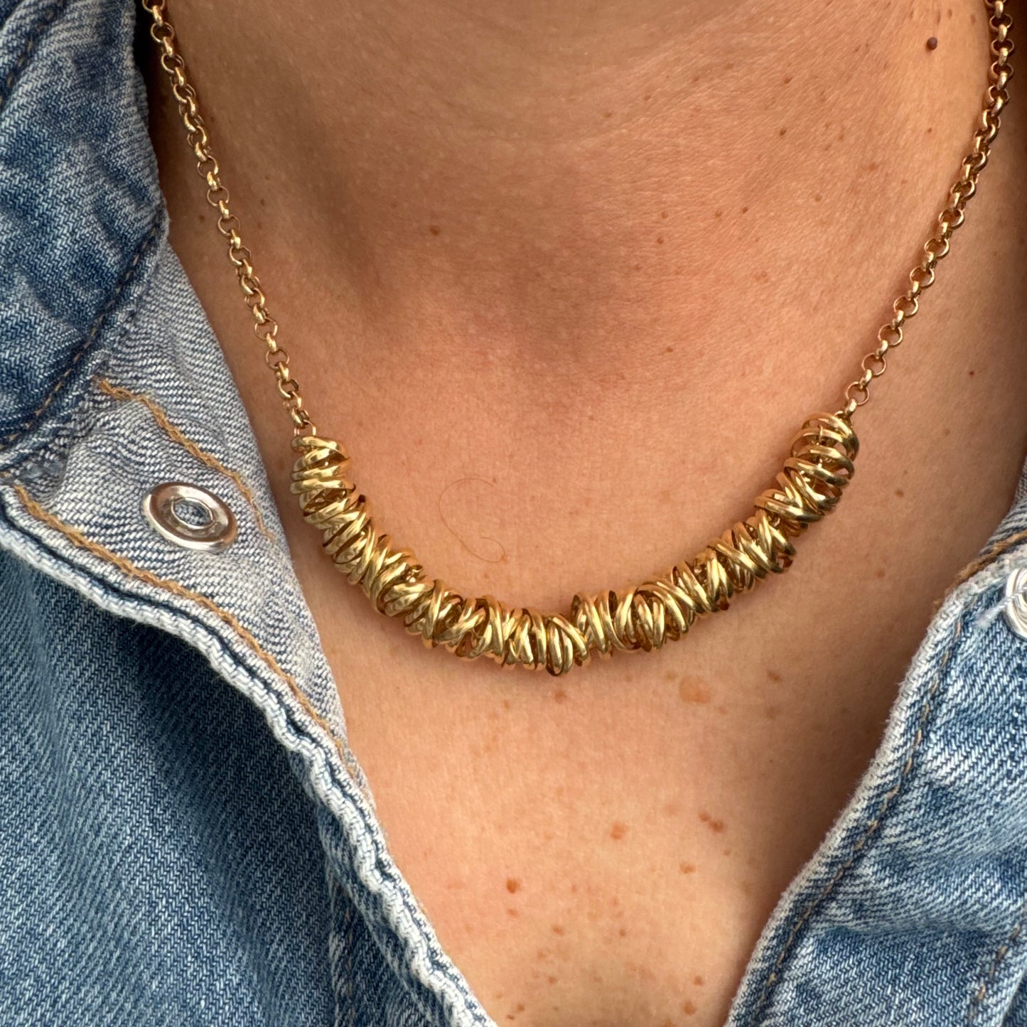 14K gold necklace featuring a series of intertwined gold rings creating a bold and sculptural design.