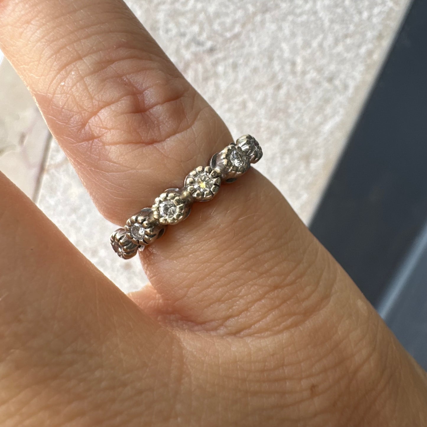 טבעת זהב 14 קראט בסגנון “חצי איטרניטי”, משובצת יהלומים עגולים בחיתוך עגול במסגרת עדינה בהשראת פרחים.