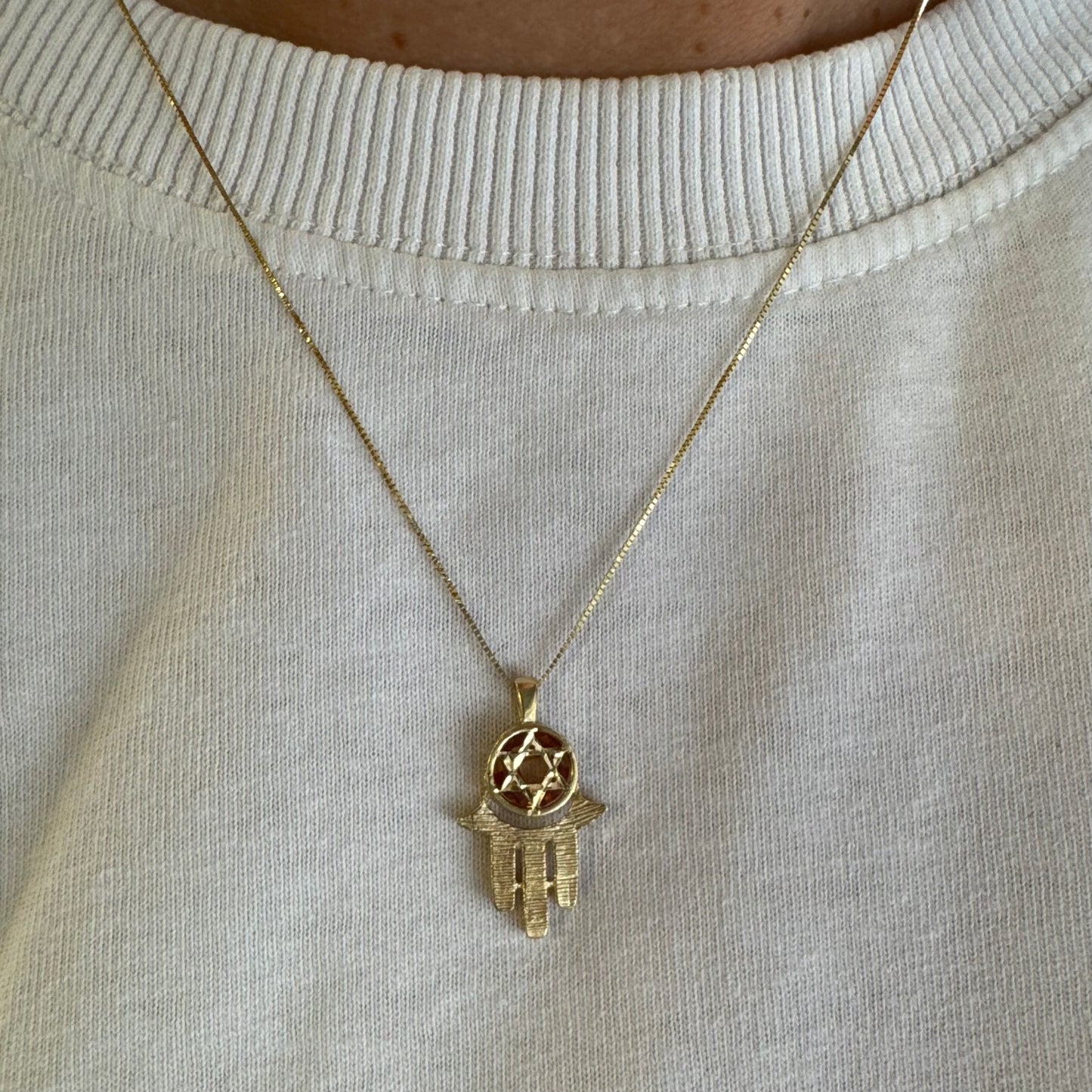 14K gold Hamsa pendant, featuring a deep orange gemstone framed by a Star of David.