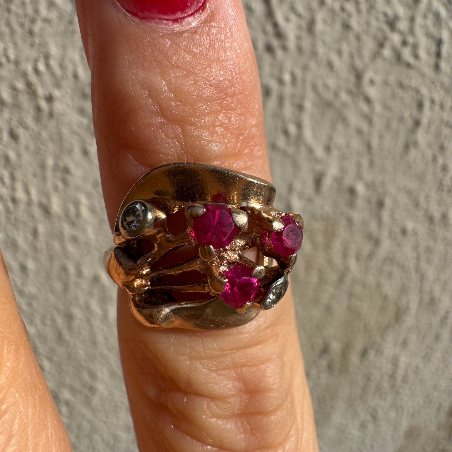 טבעת זהב צהוב 14 קראט, משובצת אבני רובי ושני יהלומים להדגשה, בעיצוב פיסולי ומלא אופי.