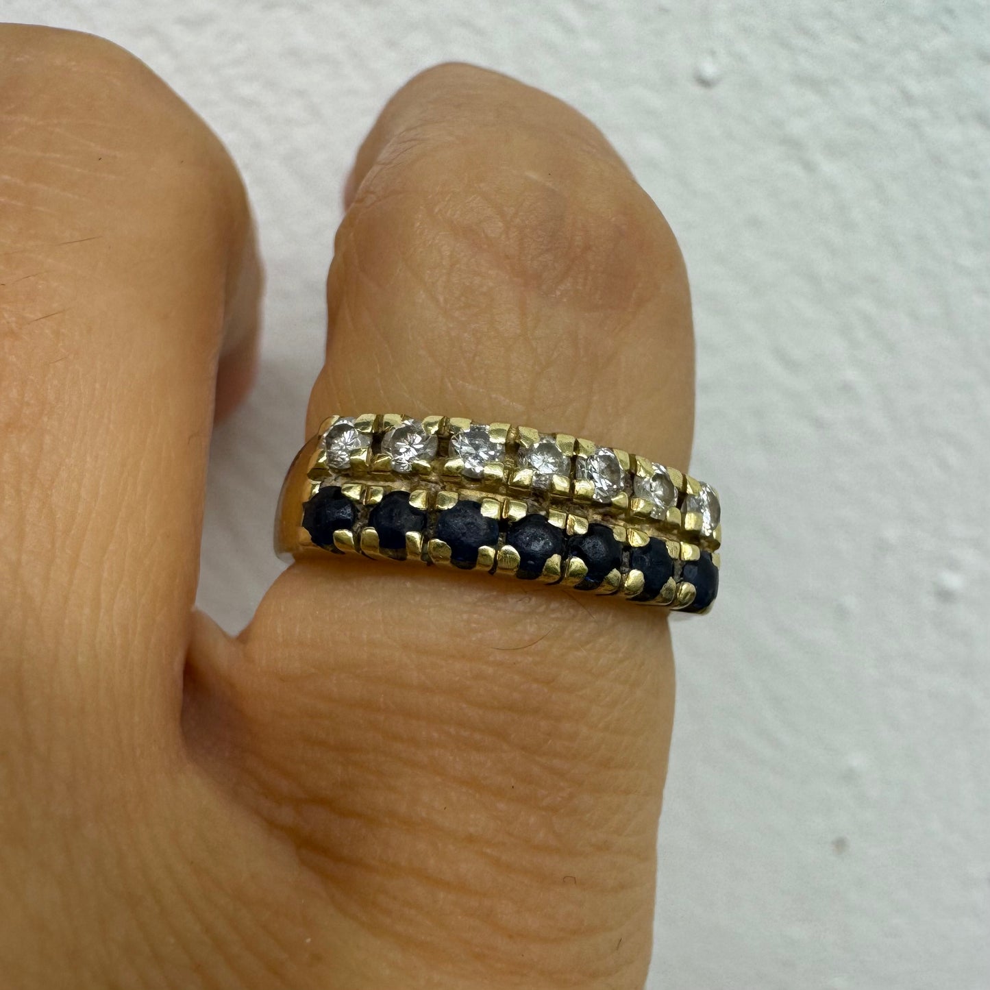 טבעת זהב צהוב 14 קראט, עם שורה של יהלומים נוצצים ושורה נוספת של ספירים כחולים.