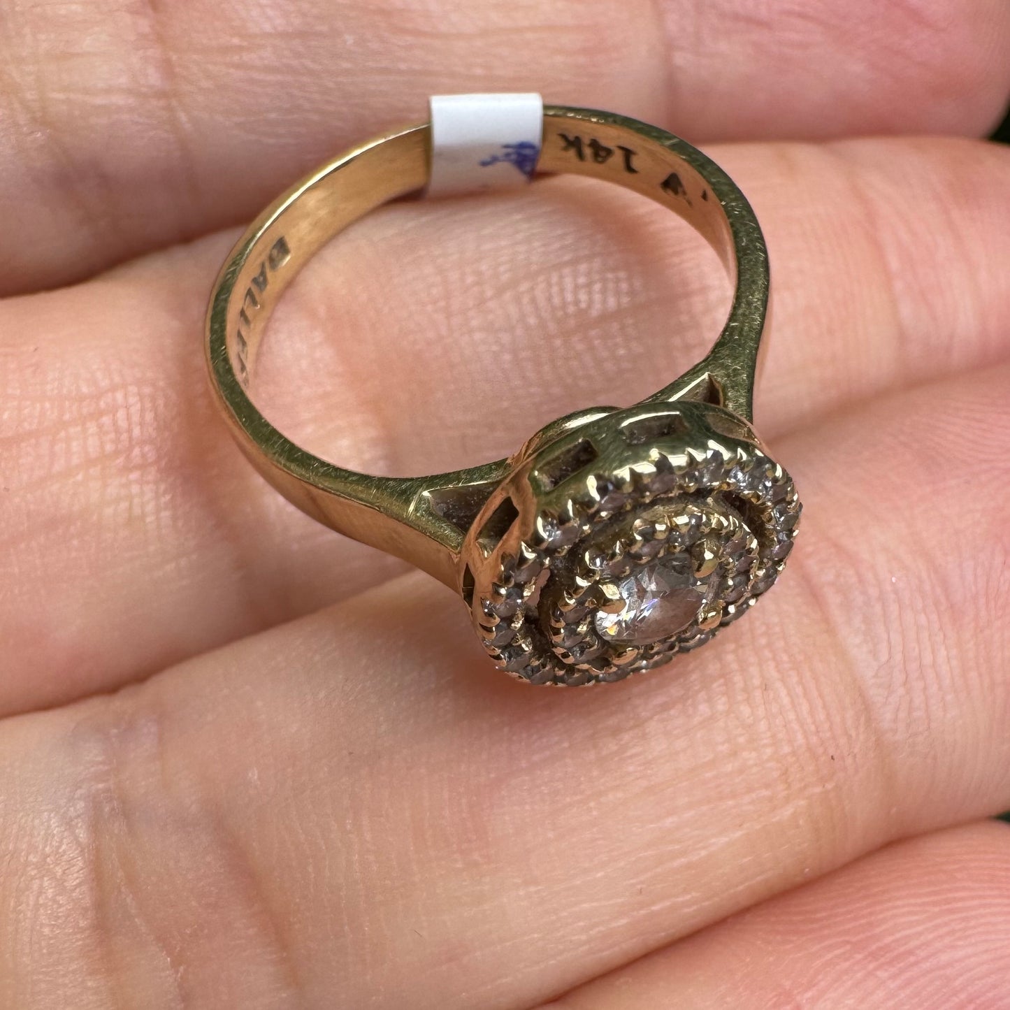 14K gold ring with a round center Diamond, surrounded by two rows of small sparkling Diamonds.