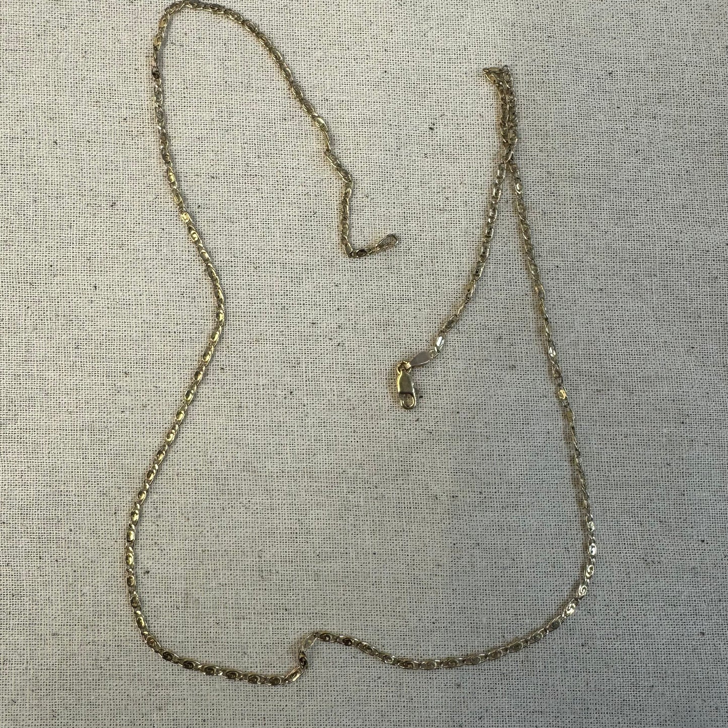 14K gold necklace featuring oval-shaped links with a subtle decorative pattern.