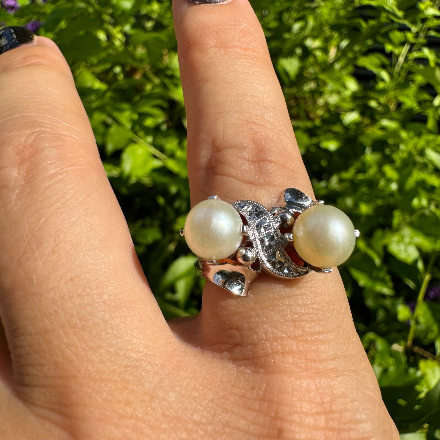 14K gold ring featuring two round white pearls set side by side, accented with a small decorative detail between them & Diamonds